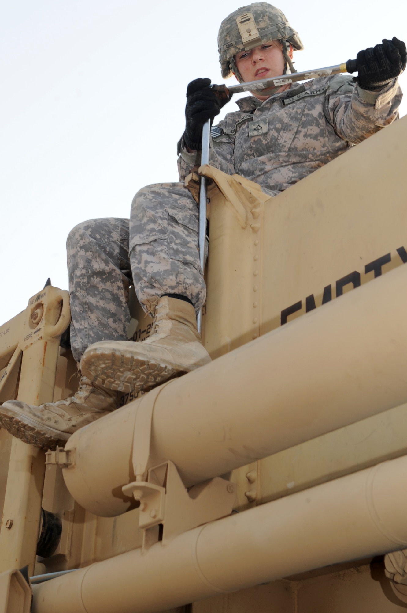 SOUTHWEST ASIA - U.S. Army Pfc. Katlin Clements , crew member tag, from the 1st Battalion, 7th Air Defense Artillery Regiment, tightens a canister in place on a heavy expandable mobile tactical truck during a missile reload certification Aug. 4, 2012. The five-solider missile reload team must reload a HEMTT with four new canisters within an hour to be considered proficient.  (U.S. Air Force photo/Master Sgt. Scott MacKay)
