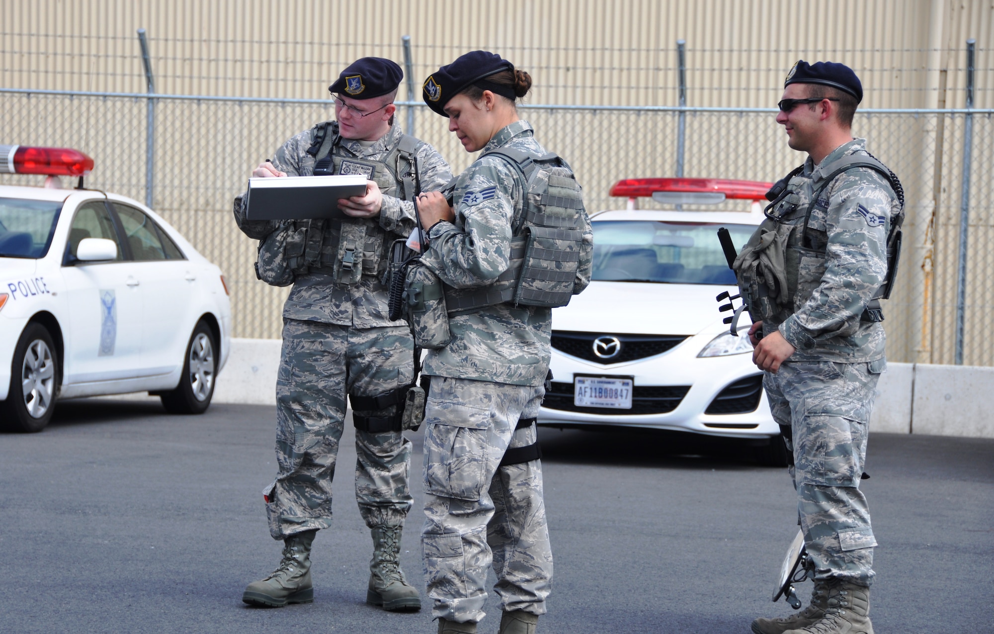 YOKOTA AIR BASE, Japan -- From the left, Staff Sgt. Lucas McLean, Senior Airman Madeline Salton and Airman 1st Class Angelo Diiorio, members of 374th Security Forces Squadron alpha flight, prepare to perform random vehicle inspections outside the supply gate Aug. 2, 2012 at Yokota Air Base, Japan. Vehicle inspections are done throughout the day as anti-terrorism measures. (U.S. Air Force photo by Senior Airman Katrina R. Menchaca)