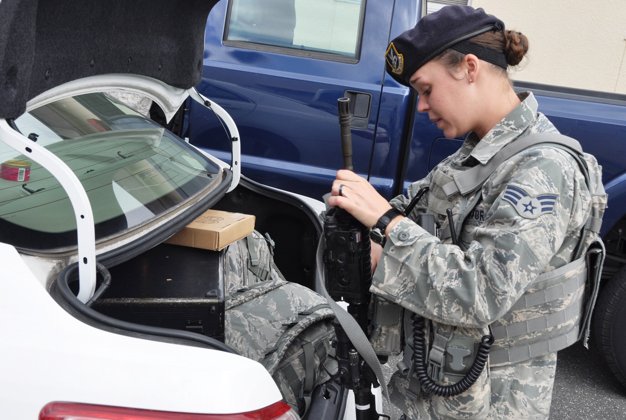 YOKOTA AIR BASE, Japan -- Senior Airman Madeline Salton, 374th Security Forces Squadron patrolman, places her gear into the back of her patrol car at Yokota Air Base, Japan, Aug. 2, 2012. Patrolmen spend much of their day in their patrol car and often bring their own lunches because they are not given a set meal time. (U.S. Air Force photo by Senior Airman Katrina R. Menchaca)