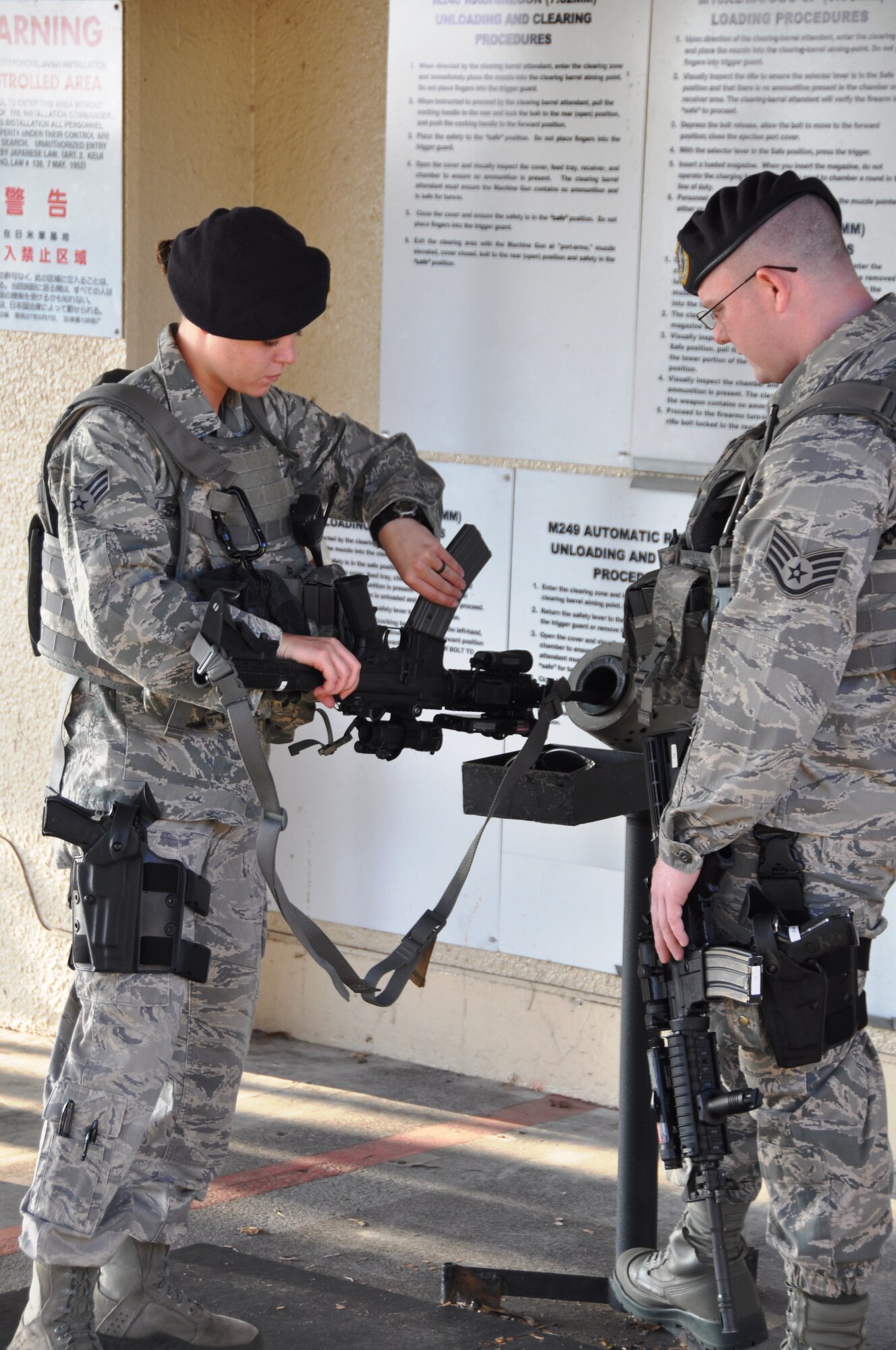 YOKOTA AIR BASE, Japan -- Senior Airman Madeline Salton, left, 374th Security Forces Squadron patrolman, clears her M-4 Carbine under the watch of Staff Sgt. Lucas McLean, 374 SFS base defense operations controller, outside the 374 SFS armory Aug. 2, 2012 at Yokota Air Base, Japan. Weapon checks are preformed at the beginning and end of every shift to ensure that they are ready for use or storage. (U.S. Air Force photo by Senior Airman Katrina R. Menchaca)
