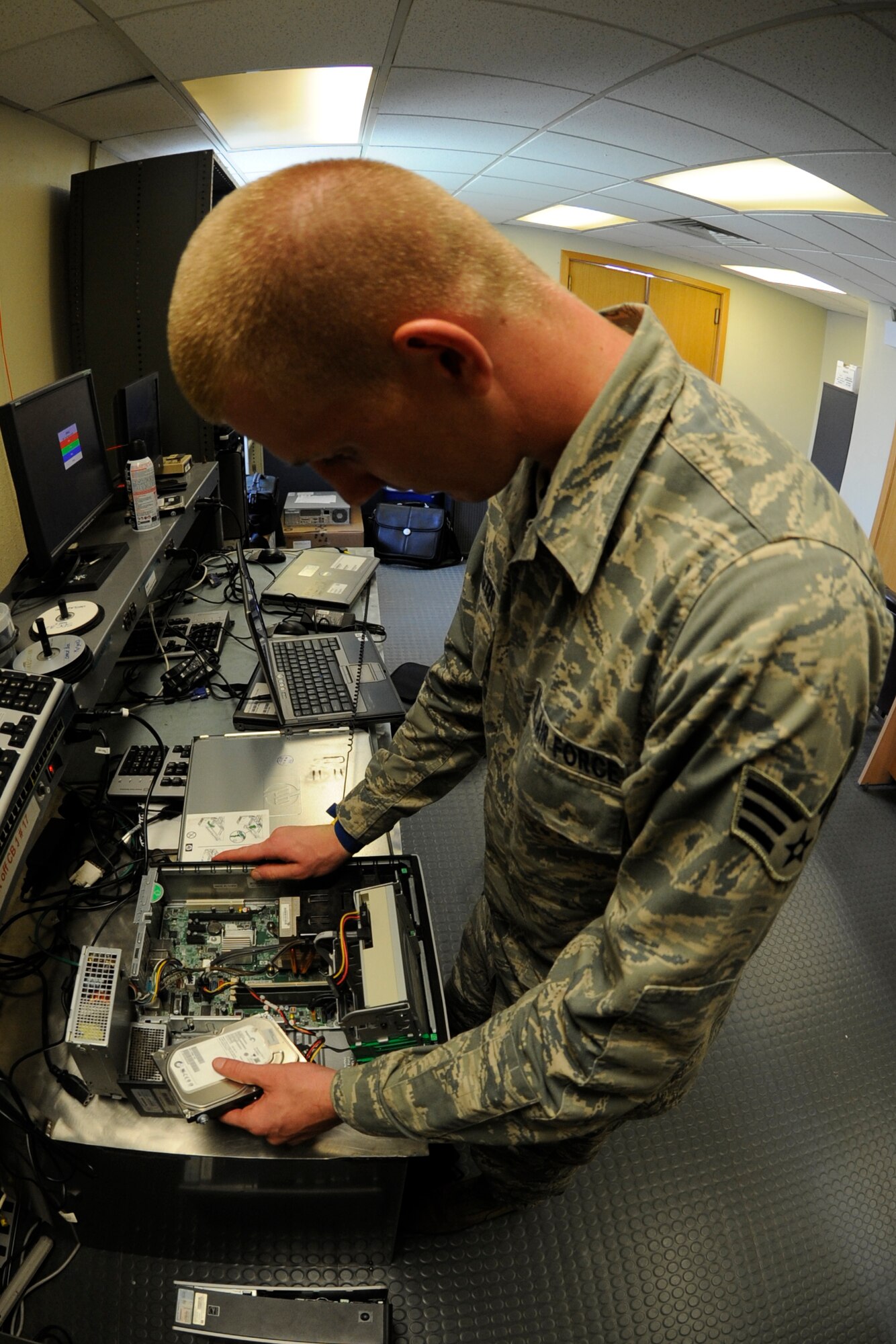 Senior Airman Joshua McMaster, 8th Communications Squadron client systems technician, works on a computer at his workcenter on Kunsan Air Base, Republic of Korea, July 26, 2012. CSTs now respond to customer computer request through the Air Force Enterprise Service Desk at Lackland Air Force Base, Texas.  (U.S. Air Force photo/Senior Airman Jessica Hines) 