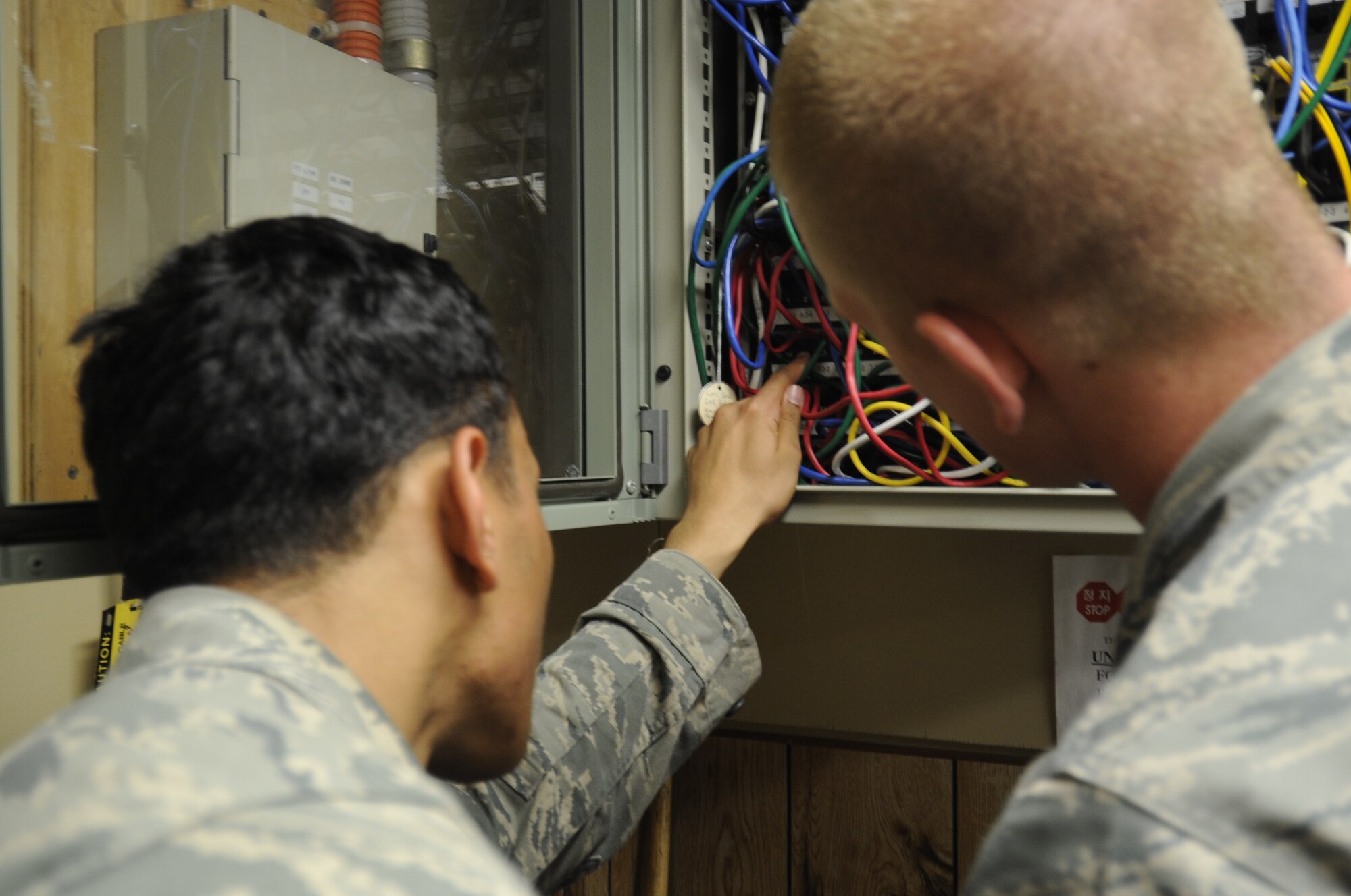 Airman 1st Class Joseph Pandolfo, left, 8th Communications Squadron client systems technician, helps identify a patch number on a switch board as Senior Airman Joshua McMaster, right, 8th CS CST, watches, July 26, 2012, on Kunsan Air Base, Republic of Korea. To trace a specific computer to the switch, the CST looks for a port number on a wall the computer is connected to and identifies the number on the switch. (U.S. Air Force photo/Senior Airman Jessica Hines)