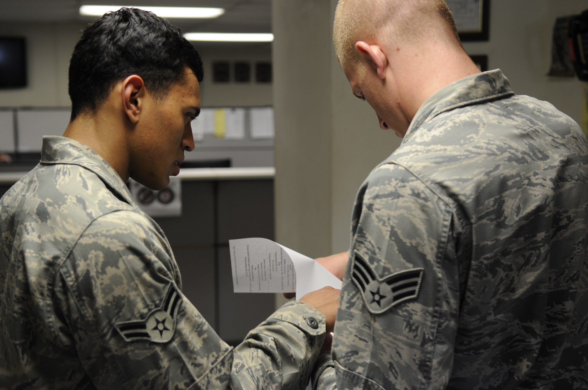 Airman 1st Class Joseph Pandolfo, left, 8th Communications Squadron client systems technician, and Senior Airman Joshua McMaster, right, 8th CS CST, look over a computer ticket request on Kunsan Air Base, Republic of Korea, July 26, 2012. Computer ticket requests are now processed through a centralized Air Force location and filtered to the appropriate installation for assistance. (U.S. Air Force photo/Senior Airman Jessica Hines) 