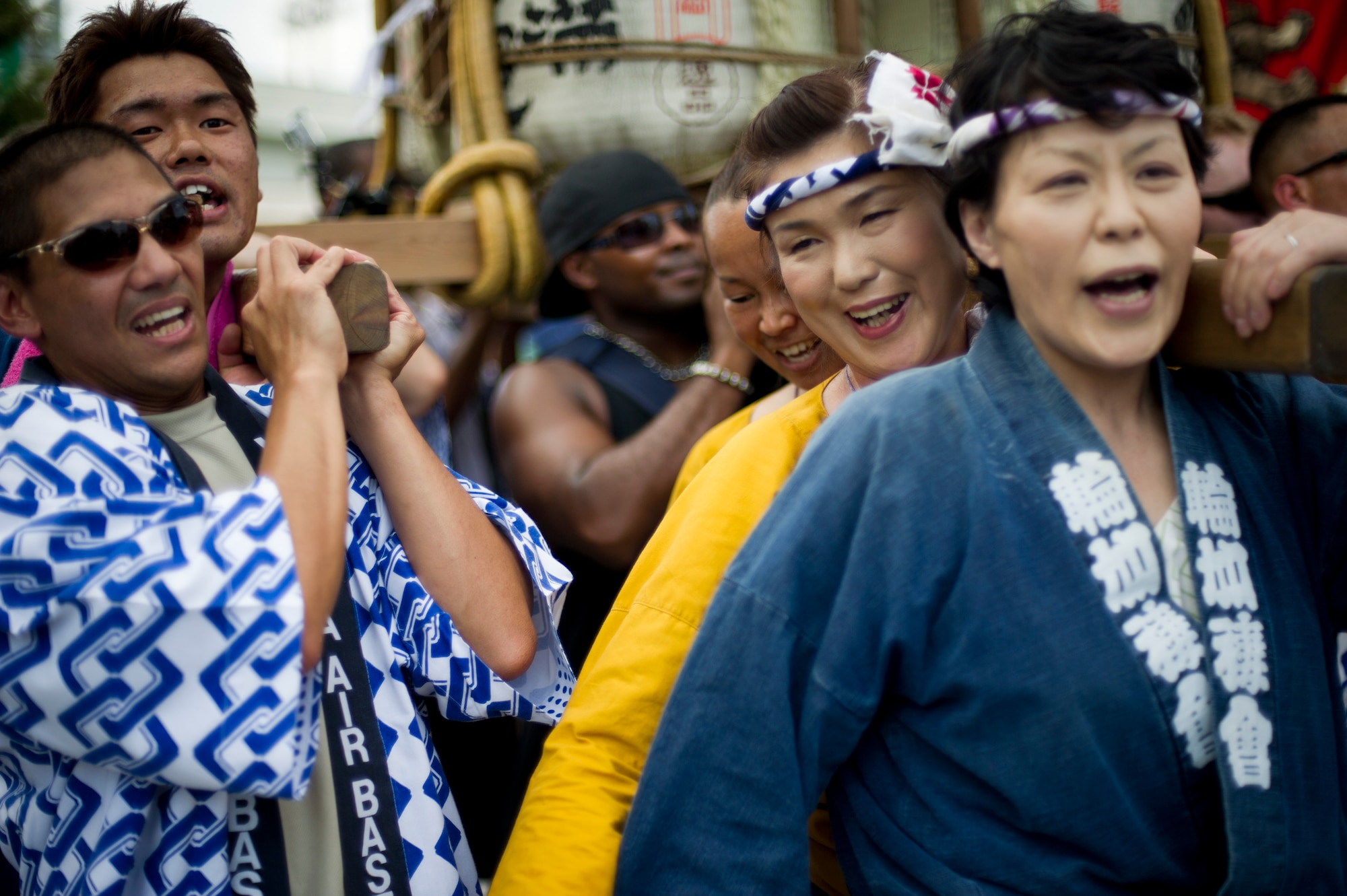 FUSSA CITY, Japan -- Military members from Yokota Air Base get help carry a mikoshi shrine with their Japanese friends during the Tanabata Festival in Fussa City, Japan, Aug. 3, 2012. The festival gives Yokota members an opportunity to meet and build friendships with the local community while experiencing Japanese culture. (U.S. Air Force photo by Staff Sgt. Stacy Moless)