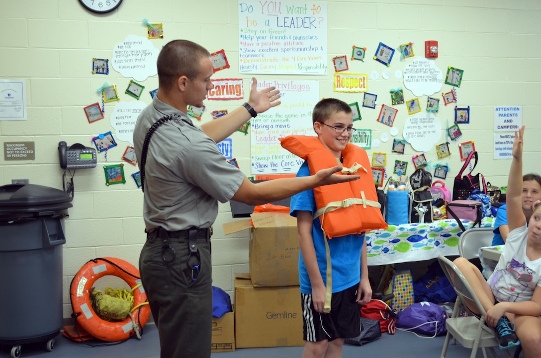 KITTANNING, Pa. — Crooked Creek Lake Student Ranger Travis November shows kids at the Kittanning YMCA the proper way to fit and wear a life jacket, July 30, 2012.