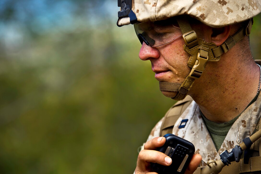 U.S. Marine Corps Capt. Chris Athanas uses a radio to call for an explosive ordnance disposal team to investigate a simulated camp to manufacture improvised explosive devices at the Kahuku Training Area during Rim of the Pacific 2012 on Oahu, Hawaii, July 31, 2012. Athanas commands Alpha Company, 1st Battalion, 3rd Marine Regiment.