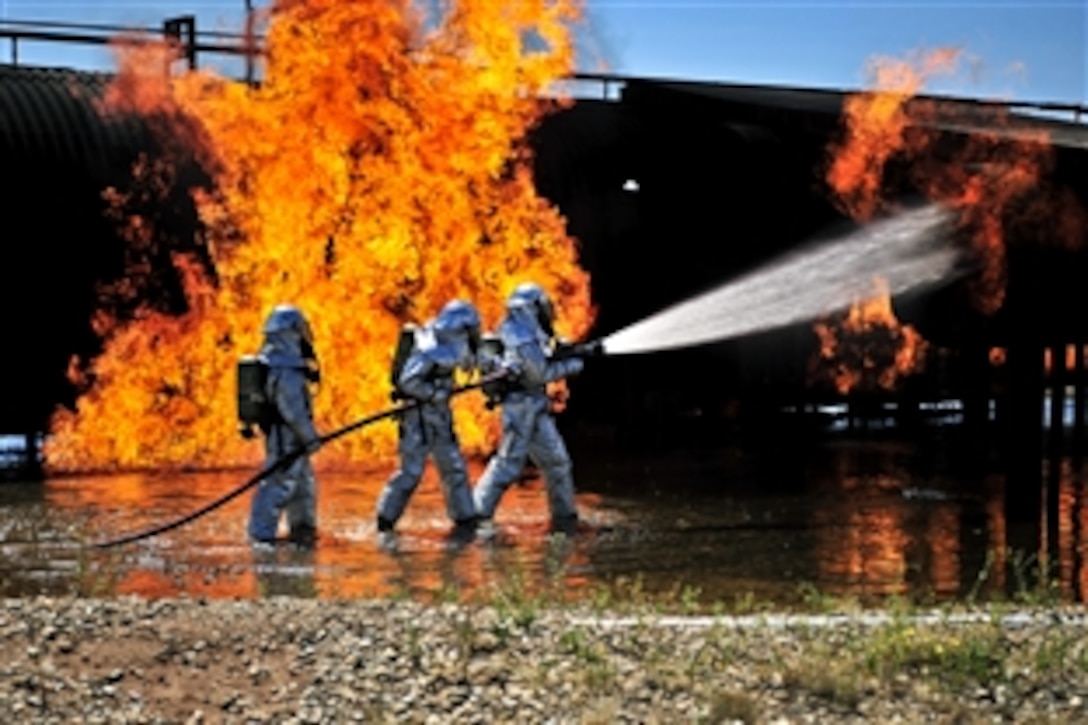Firefighters assigned to the 27th Special Operations Civil Engineer Squadron work to extinguish a simulated engine fire on Cannon Air Force Base, N.M., Aug. 2, 2012. 