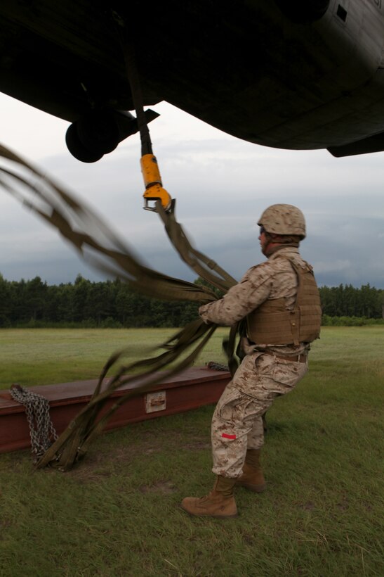 Cpl. Nash Helms, a landing support specialist with Combat Logistics Battalion 8, 2nd Marine Logistics Group, wrangles the load-bearing ropes of a Sikorsky CH-53E Super Stallion during a training mission near Camp Lejeune, N.C., July 24, 2012. The helicopter’s ascent tightens the ropes, which must remain untangled to properly stabilize the load. Helms’ guidance ensures the ropes remain uncrossed and protects his crew members from becoming entangled.