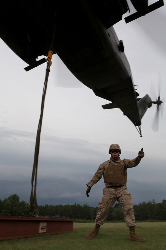 Cpl. Nash Helms, a landing support specialist with Combat Logistics Battalion 8, 2nd Marine Logistics Group, signals his crew that the Sikorsky CH-53E Super Stallion’s cargo is secure during a training mission near Camp Lejeune, N.C., July 24, 2012. The Super Stallion’s ability to carry internal and external loads helps Marines quickly transport needed war supplies to geographically dispersed areas. Close communication between the loading crew on the ground and the pilots allows for quick, safe loading during operations.
