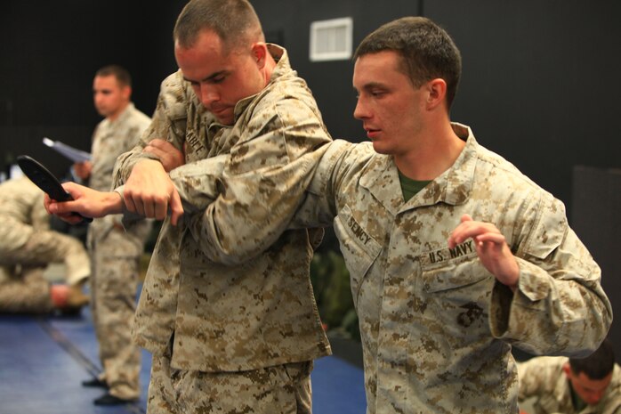 Petty Officer 3rd Class Michael J. Sency (right), a religious program specialist with 2nd Marine Logistics Group, practices a handheld weapon technique with Cpl. Adams Sable, a fellow student of a Marine Corps Martial Arts Program Instructor course, aboard Camp Geiger, N.C., July 26, 2012. The course included 100 hours of instruction and grueling practical application in a fast-paced training environment.  Sency graduated the course aboard Camp Geiger, N.C., Aug. 1, 2012.  Sency is now part of a very small group of RPs who are qualified to teach Marine Corps Martial arts. 