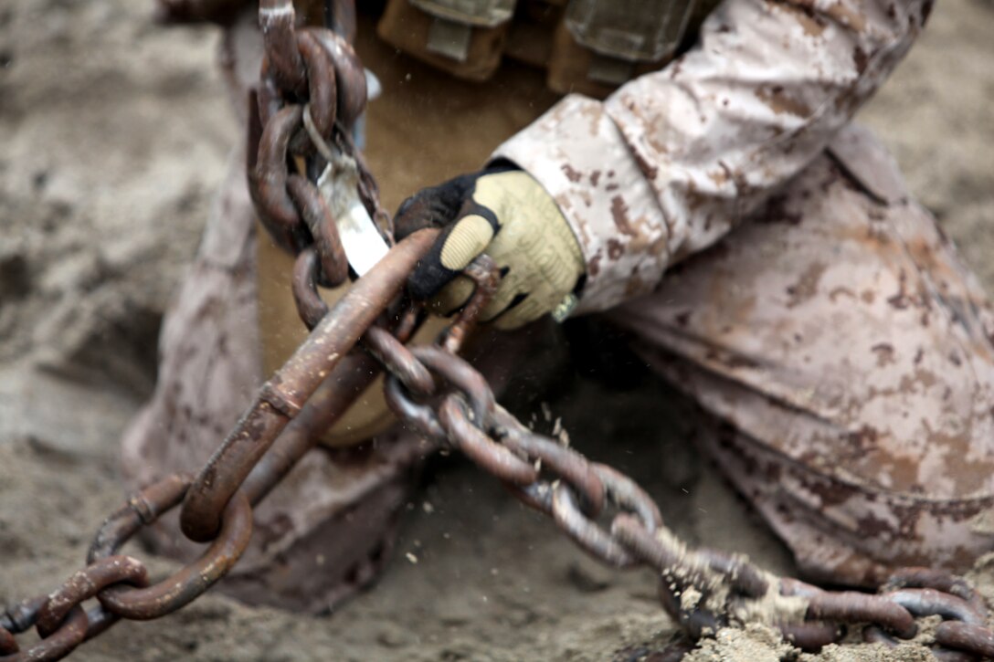 A Marine with Combat Logistics Battalion 8, 2nd Marine Logistics Group, creates a loop with chains, which he used to attach a Humvee to a wrecker during a field training exercise aboard Camp Lejeune, N.C., July 31, 2012. The troops trained in many ways to improve their skills and confidence operating the vehicles in different terrains.  The week-long exercise was designed to prepare the troops for their upcoming deployment to Afghanistan.  