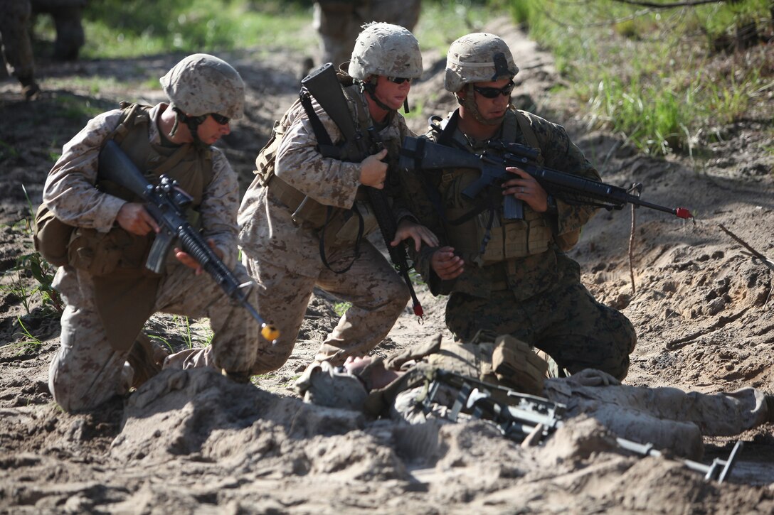 Three Marines with Combat Logistics Battalion 8, 2nd Marine Logistics Group rush to provide medical care to Lance Cpl. Brandon A. McNeill, a simulated casualty after a simulated improvised explosive device goes off during a field training exercise aboard Camp Lejeune, N.C., Aug. 1, 2012.  The troops underwent multiple scenarios from firefights to explosions during the week-long exercise, which was part of the unit’s pre-deployment training.  The battalion is scheduled to deploy to Afghanistan in the upcoming months.