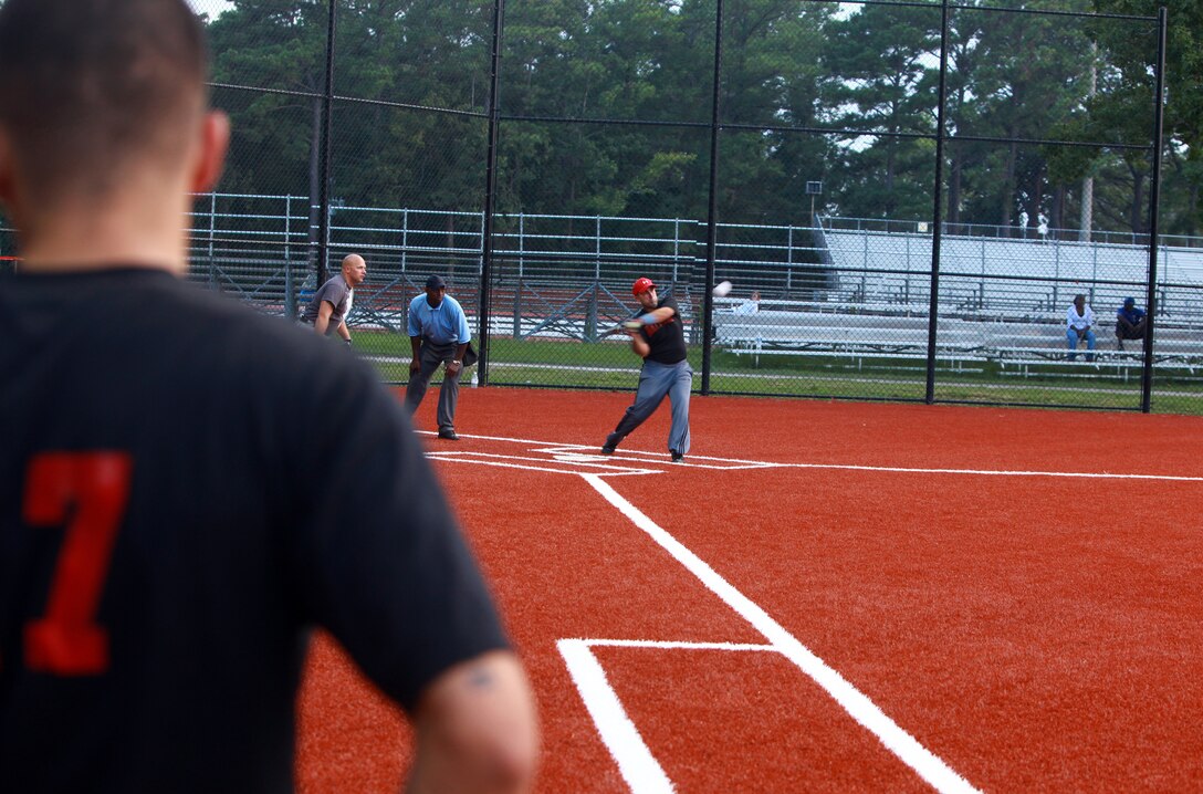 Lance Cpl. Erik Rivera, a towed artillery systems technician with Combat Logistics Regiment 2, 2nd Marine Logistics Group, watches a teammate’s at-bat during a softball game aboard Camp Lejeune, N.C., Aug. 2, 2012. Most Marines playing in the softball league are on their respective units’ teams. The league has been an ideal way for Marines to boost morale and camaraderie amongst themselves. (Photo by Sgt. Rachael K. A. Moore)