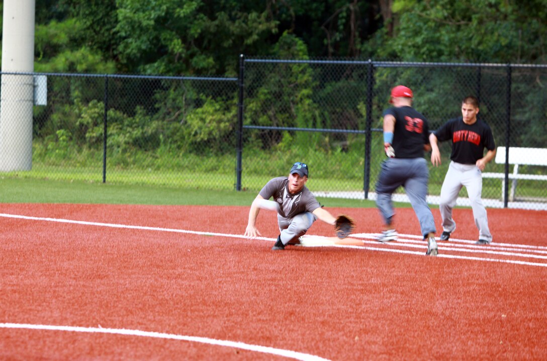 Cpl. Cody A. Sanborn, an outfielder for "Dirty Herd", beats a throw to first base during a softball game at Camp Lejeune, N.C., Aug. 2, 2012.  Dirty Herd is made up of Marines from Combat Logistics Regiment 2, 2nd Marine Logistics Group.  Off the field, Sanborn is a logistics vehicle system operator.  (Photo by Sgt. Rachael K. A. Moore)