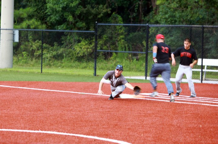 Cpl. Cody A. Sanborn, an outfielder for "Dirty Herd", beats a throw to first base during a softball game at Camp Lejeune, N.C., Aug. 2, 2012.  Dirty Herd is made up of Marines from Combat Logistics Regiment 2, 2nd Marine Logistics Group.  Off the field, Sanborn is a logistics vehicle system operator.  (Photo by Sgt. Rachael K. A. Moore)