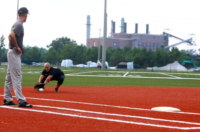 Lance Cpl. Justin C. Summerfield, the third baseman for "Dirty Herd", stops a grounder before making the play at firstbase during a softball game at Camp Lejeune, N.C., Aug. 2, 2012.  Dirty Herd is made up of Marines from Combat Logistics Regiment 2, 2nd Marine Logistics Group.  Off the field, Summerfield is a logistics vehicle system operator.  (Photo by Sgt. Rachael K. A. Moore)