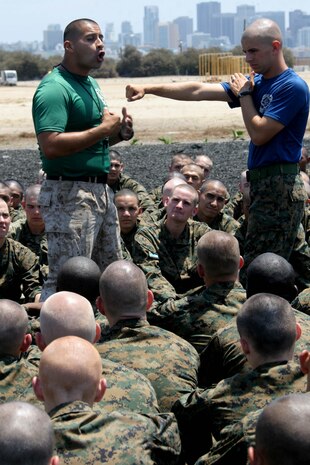 Staff Sgt. Jonh Saracay, martial arts instructor, Instructional Training Company, Support Battalion, (left) and Sgt. Jeffrey Belyeu, drill instructor, Company M, 3rd Recruit Training Battalion, demonstrate to recuits how to execute techniques Aug. 3 aboard Marine Corps Recruit Depot San Diego. MAI's introduce the Marine Corps Martial Arts Program to the recruits and how they can be successful with it in their Marine Corps career.
