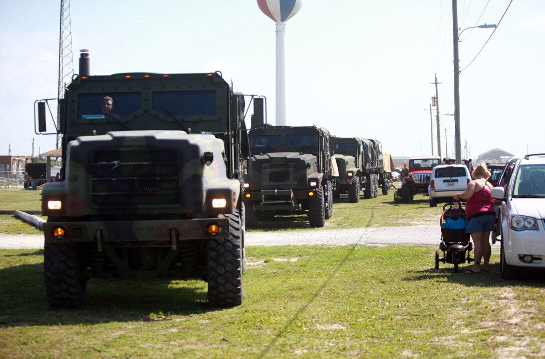 Medium Tactical Vehicle Replacements with 8th Engineer Support Battalion, 2nd Marine Logistics Group drive past families during the battalion’s family day at Onslow Beach aboard Camp Lejeune, N.C., July 19, 2012. Before the fun day, the battalion conducted an eight-mile hike. (U.S. Marine Corps photo by Pfc. Franklin E. Mercado)