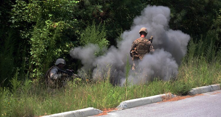 Marines with Company E, 2nd Battalion, 2nd Marine Regiment, 2nd Marine Division, get engulfed with black smoke from a faux improvised explosive device. Marines and sailors with Company E practiced counter-IED training July 30- August 2.