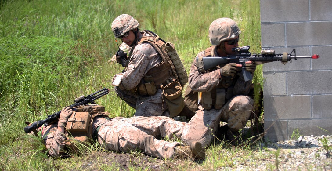 Cpl. John L. Caldwell (middle), a fire team leader with 2nd Battalion, 2nd Marine Regiment, 2nd Marine Division, and State College, Pa., native, radios in a casualty, as Lance Cpl. Jared P. Kalarovich, a rifleman with the unit and Port St. Lucie, Fla., native, provides security. Marines and sailors with Company E practiced counter-IED training July 30- August 2.