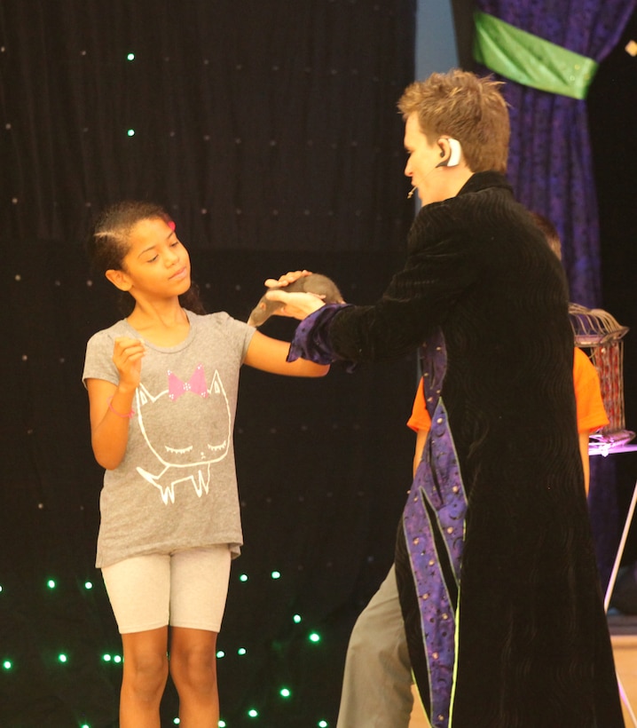 A military child pets magician Jeff Jones’ rat at the grand finale of the summer reading program at Marston Pavilion aboard Marine Corps Base Camp Lejeune Aug. 3. The rat, one of Jones’ hit acts, was comically brought to the stage through an amusing act with some unsuspecting audience members.