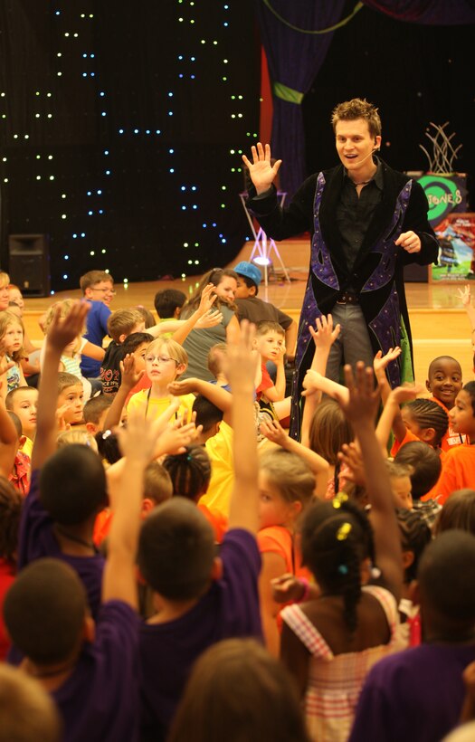 Magician Jeff Jones walks down an isle between children at the grand finale for the summer reading program at Marston Pavilion aboard Marine Corps Base Camp Lejeune Aug. 3. Jones loves to interact with his audience and decided to find an unsuspecting member for his next magically comical act.