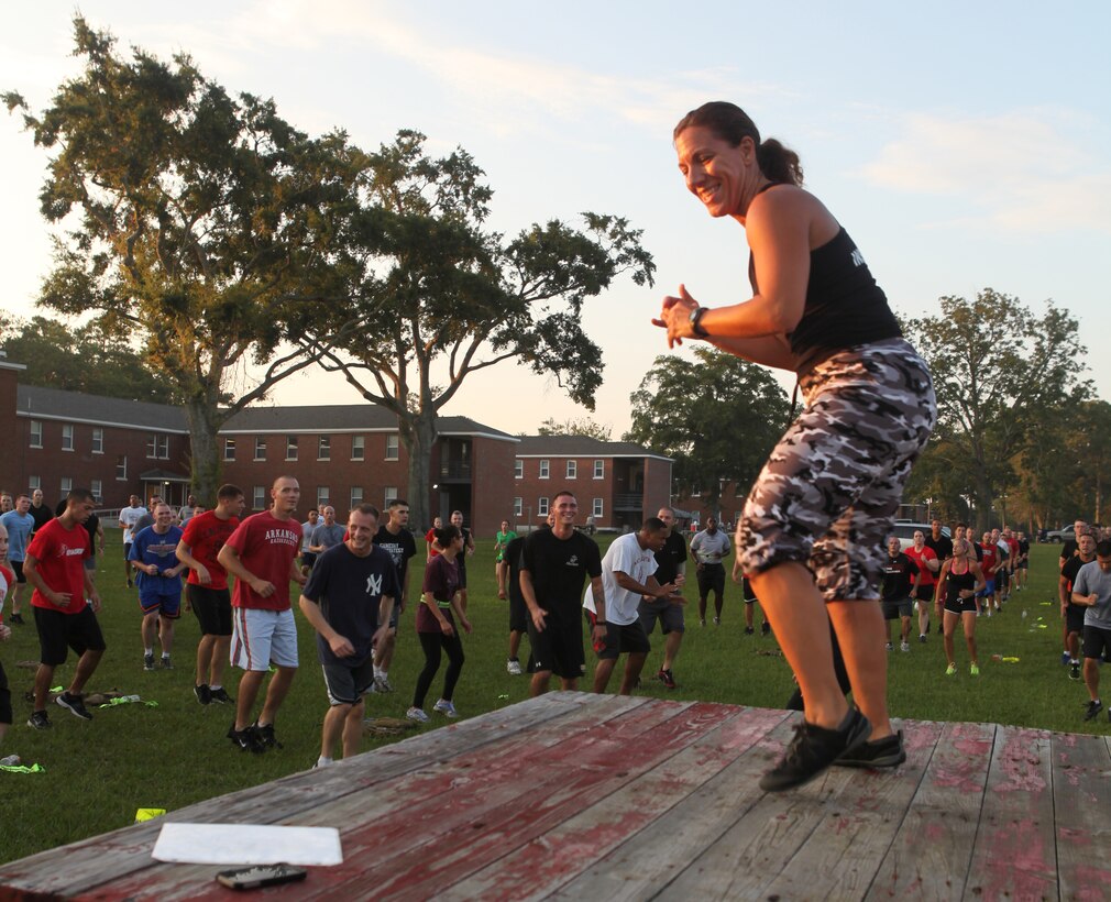 Company A, Headquarters and Support Battalion’s first sergeant, 1st Sgt. Nicole Freres, smiles as she leads the battalion in Semper Fit exercises aboard Marine Corps Base Camp Lejeune Aug. 3. Freres who is a Semper Fit instructor is thrilled to be leading her final battalion physical training doing something she is particularly passionate about before retiring late this month. 
