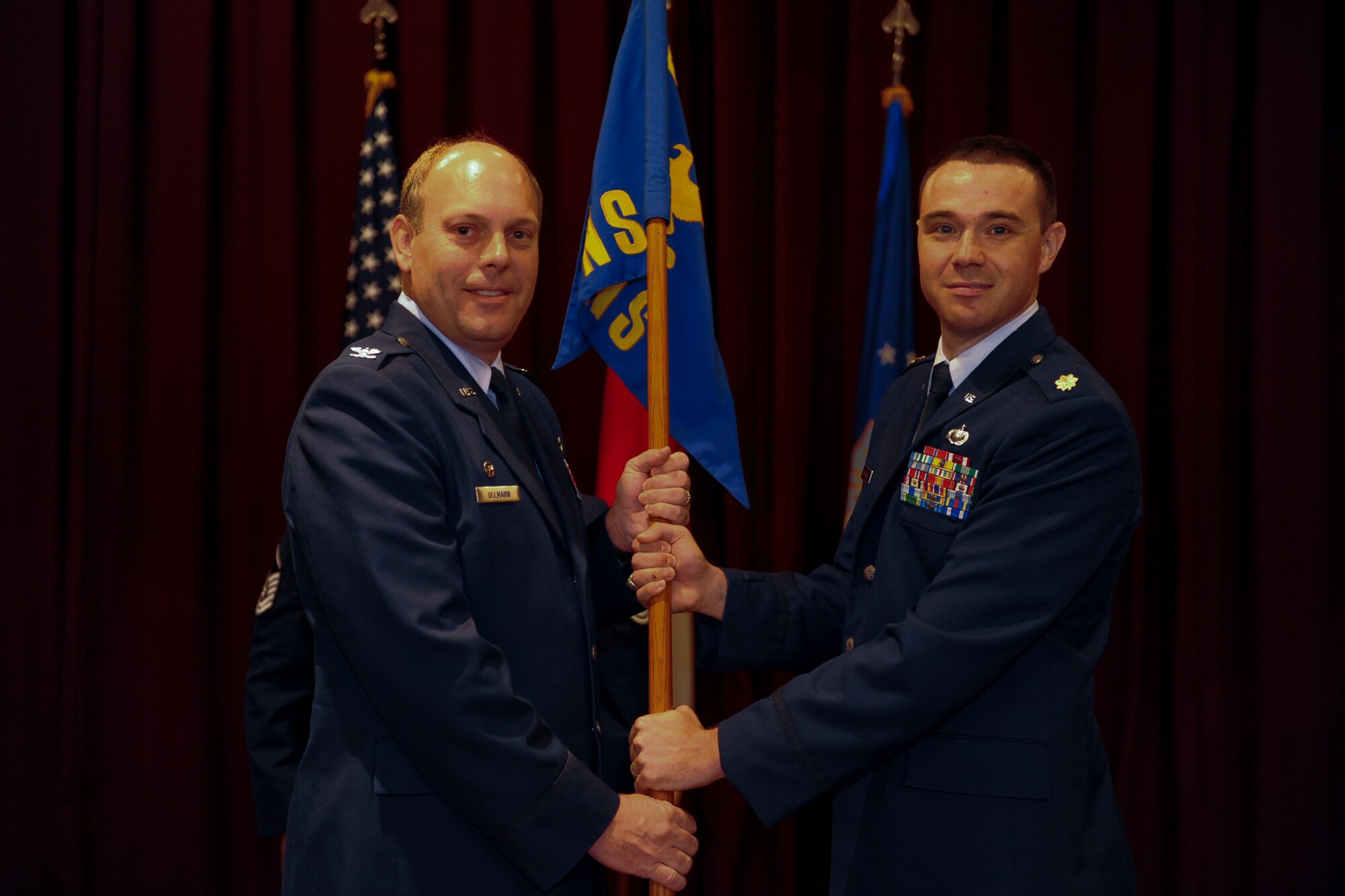 U.S. Air Force Maj. Calvin Hodgson, newly appointed 18th Contracting Squadron commander, accepts the guidon from Col. Jeffrey Ullman, 18th Mission Support Group commander, during an Assumption of Command ceremony on Kadena Air Base, Japan, Aug. 8, 2012. Hodgson comes from Laughlin Air Force Base, Texas, which is under the command of the Air Education and Training Command. (U.S. Air Force photo/Airman 1st Class Justin Veazie)