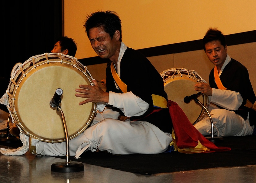 Members of the Samulnori group play traditional Korean instruments called janggu in the base theater at Kunsan Air Base, Republic of Korea, Aug. 6, 2012. Each of the four instruments the group played represent a different weather condition. (U.S. Air Force photo/Senior Airman Marcus Morris)