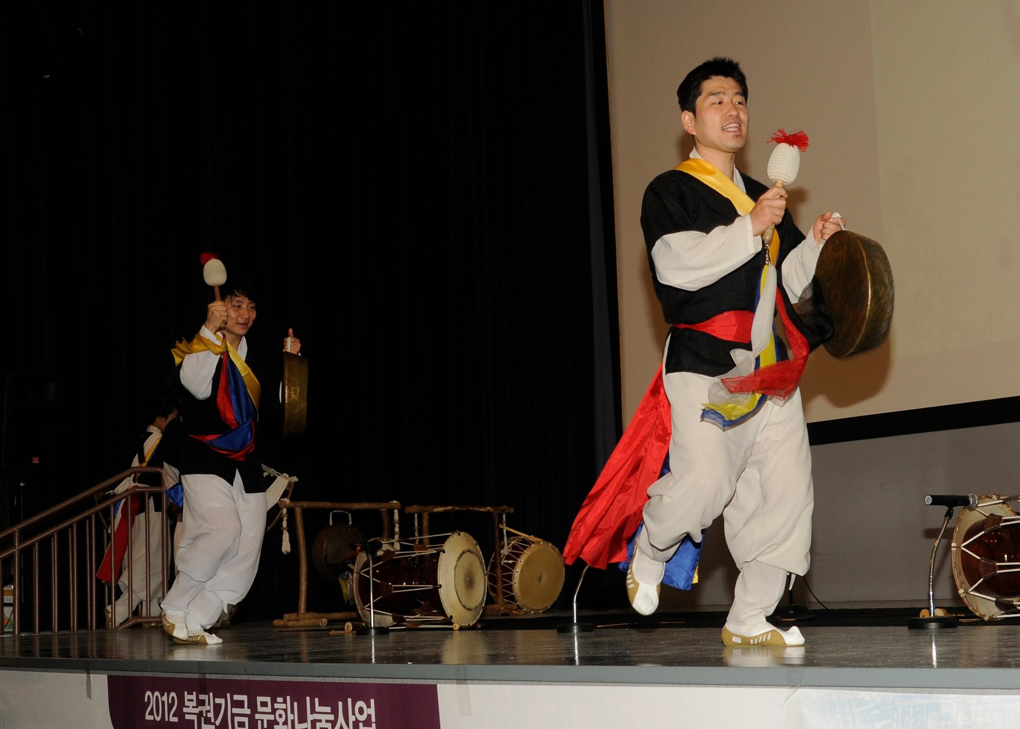 Members of the Samulnori group play traditional Korean instruments called kkwaenggwari (small gong), in the base theater at Kunsan Air Base, Republic of Korea, Aug. 6, 2012. The group performed folk songs along with choreographed dancing with percussion instruments. (U.S. Air Force photo/Senior Airman Marcus Morris)