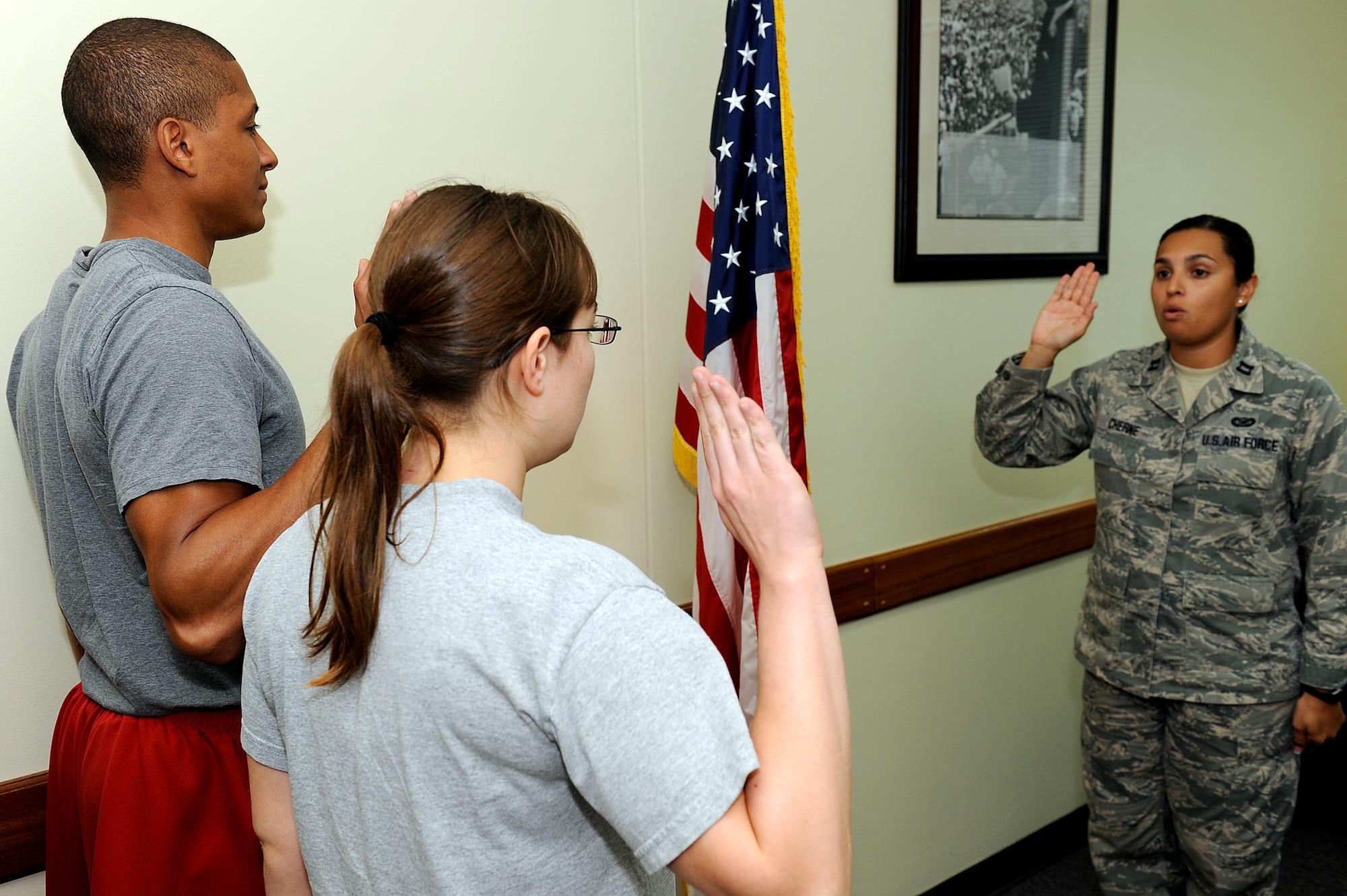 Logattrace Leonard (left) and Kristina Baker recite the oath of enlistment with U.S. Air Force Capt. Natassia Cherne, 18th Wing Public Affairs deputy public affairs officer, on Kadena Air Base, Japan, Aug. 7, 2012. Leanoard, a Cleveland, Ga., native and spouse of U.S. Air Force Airman 1st Class Christina Leonard who is currently stationed on Kadena, enlisted in the “open mechanical” career field. Baker, an Abilene, Kan., native, is married to U.S. Air Force Airman 1st Class Haden Baker who is stationed on Camp Zama in Mainland Japan, and enlisted into the “radio frequency transmissions” career field. (U.S. Air Force photo/Airman 1st Class Maeson L. Elleman)