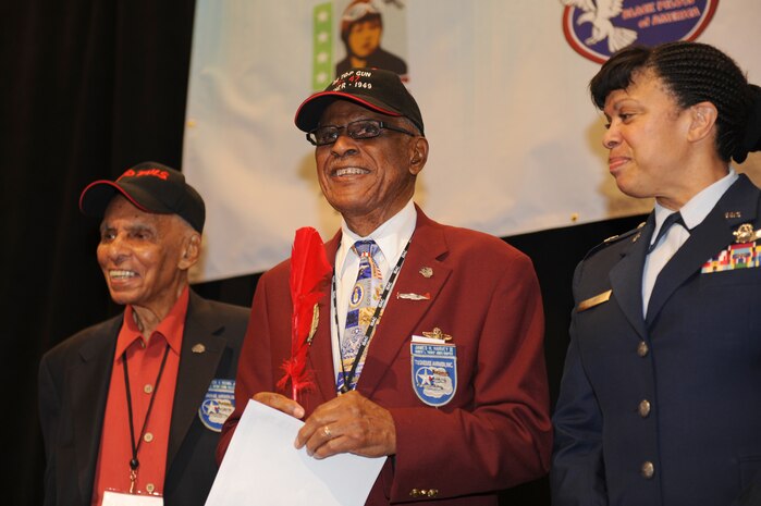 Roscoe Brown Jr., Tuskegee Airman, and U.S. Air Force Brig. Gen. Stayce Harris, U.S. Africa Command mobilization assistant to the commander, accompany U.S. Air Force retired Lt. Col. James Harvey as he receives a certificate and red feather, giving him the title of honorary member of the Red Tails Aug. 1, 2012, at the Las Vegas Hotel and Casino, Nev. Harvey was presented with the title last year at a Tuskegee reunion in Orlando, Fla., but was unable to receive the award. (U.S. Air Force photo by Staff Sgt. William P.Coleman)  