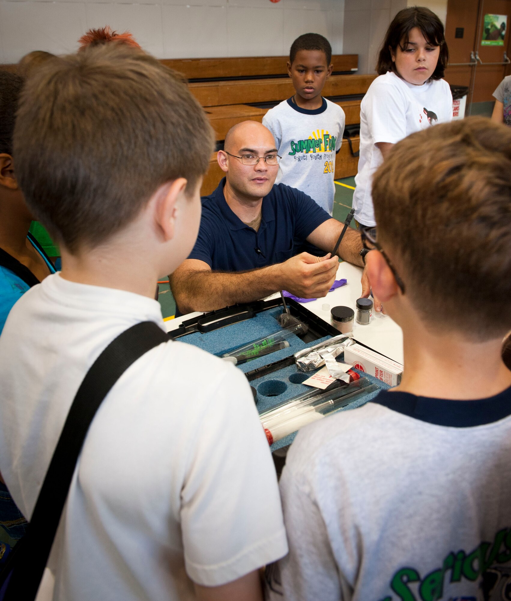 YOKOTA AIR BASE, Japan -- Investigator Thomas Bonte, 374th Security Forces Squadron, demonstrates the process for lifting fingerprints during a crime scene investigation camp at the Youth Center at Yokota Air Base, Japan, July, 30, 2012. During the camp, the children had the chance to lift fingerprints from a compact disc, giving them an inside look at how security forces investigators catch a culprit. (U.S. Air Force photo by Airman 1st Class Krystal M. Garrett) 
