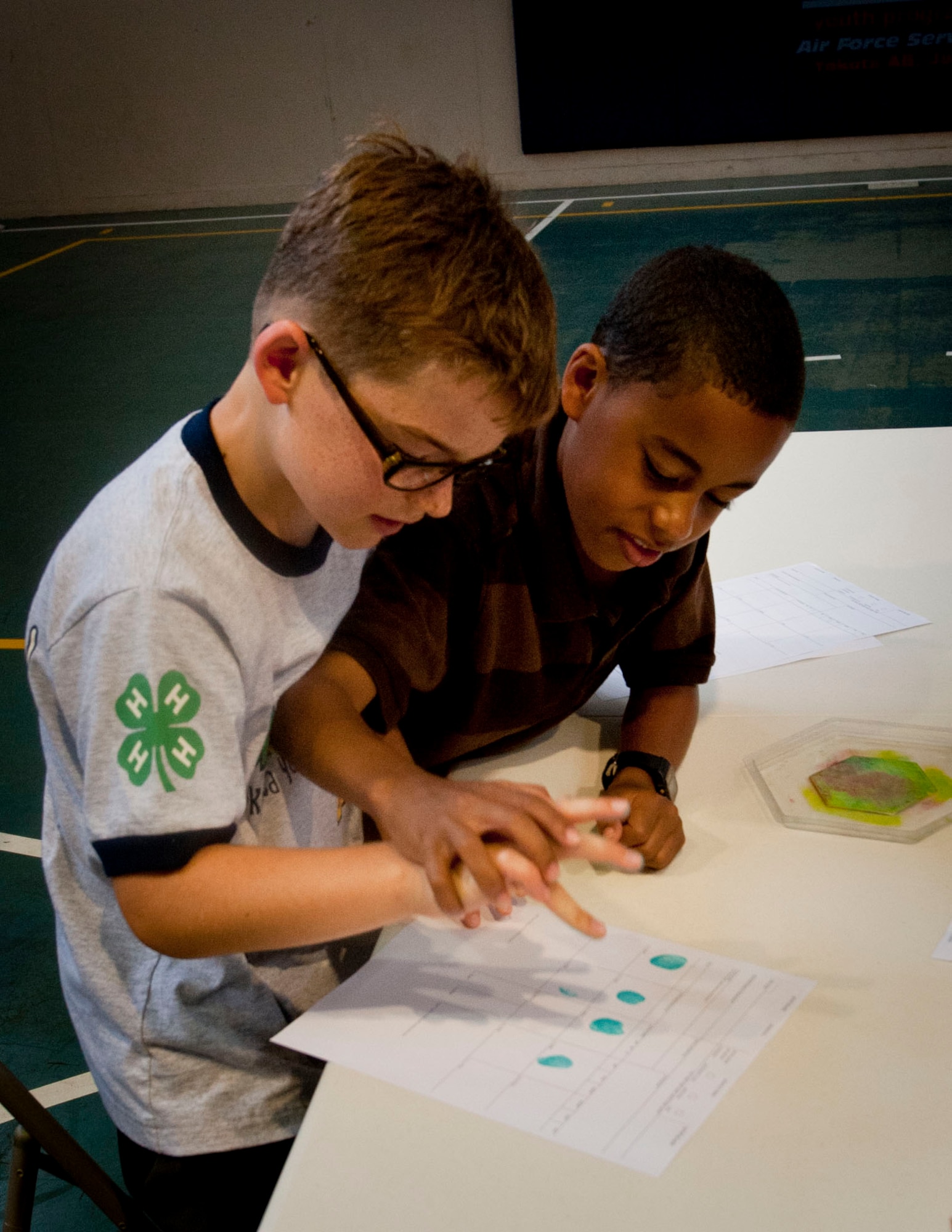 YOKOTA AIR BASE, Japan -- Brian McKinley, 10, and Alex Corman, 9, practice fingerprinting one another during a crime scene investigation camp at the Youth Center at Yokota Air Base, Japan, July, 30, 2012. The children learned hands-on how to identify different types of fingerprints by identifying their own. (U.S. Air Force photo by Airman 1st Class Krystal M. Garrett) 