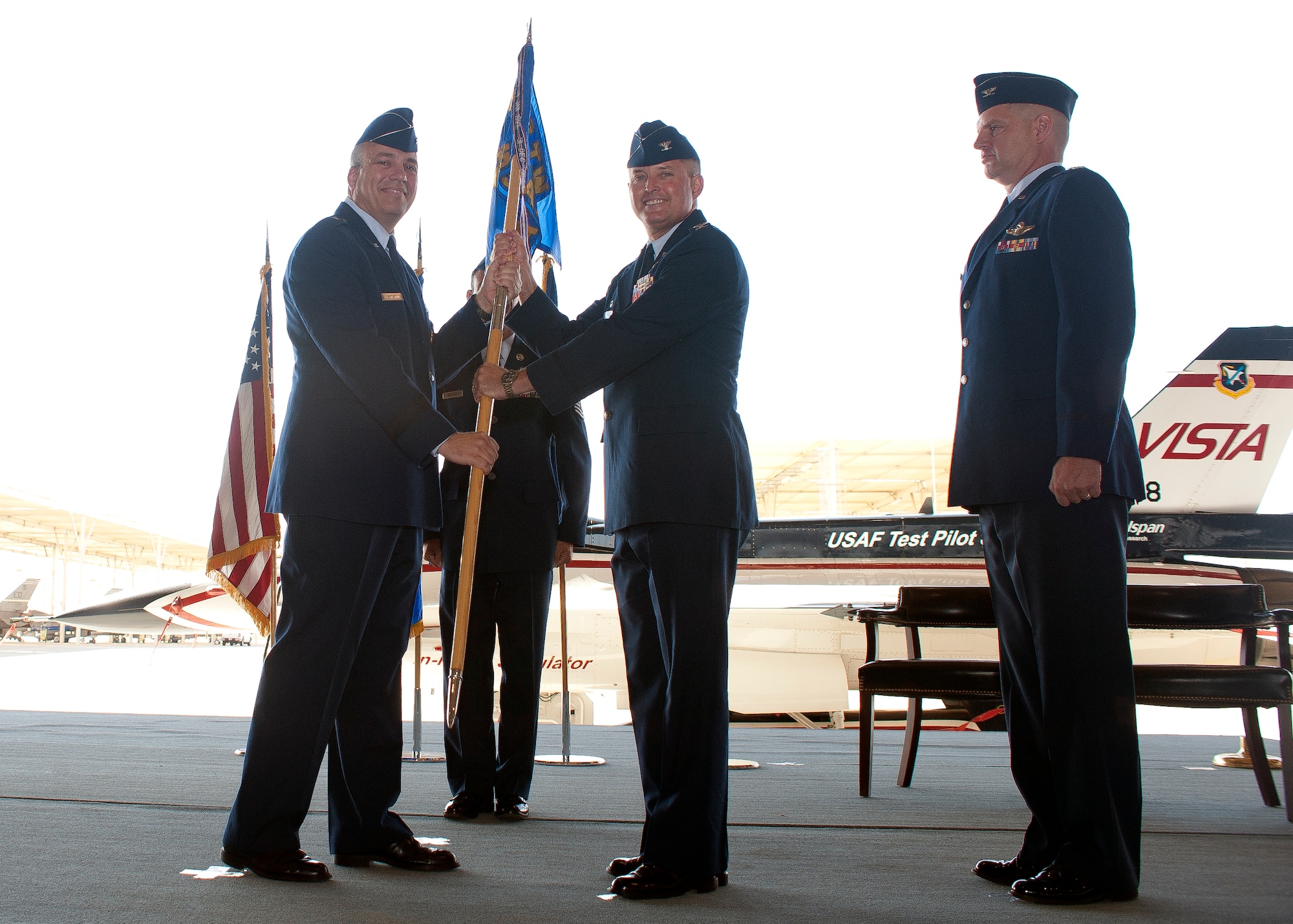 Brig. Gen. Michael T. Brewer, 412th Test Wing commander, hands Col. Lawrence "Lars" Hoffman the United States Test Pilot School guidon, making Hoffman the 41st commandant during a ceremony Aug. 3. (Air Force Photo by Ethan Wagner)