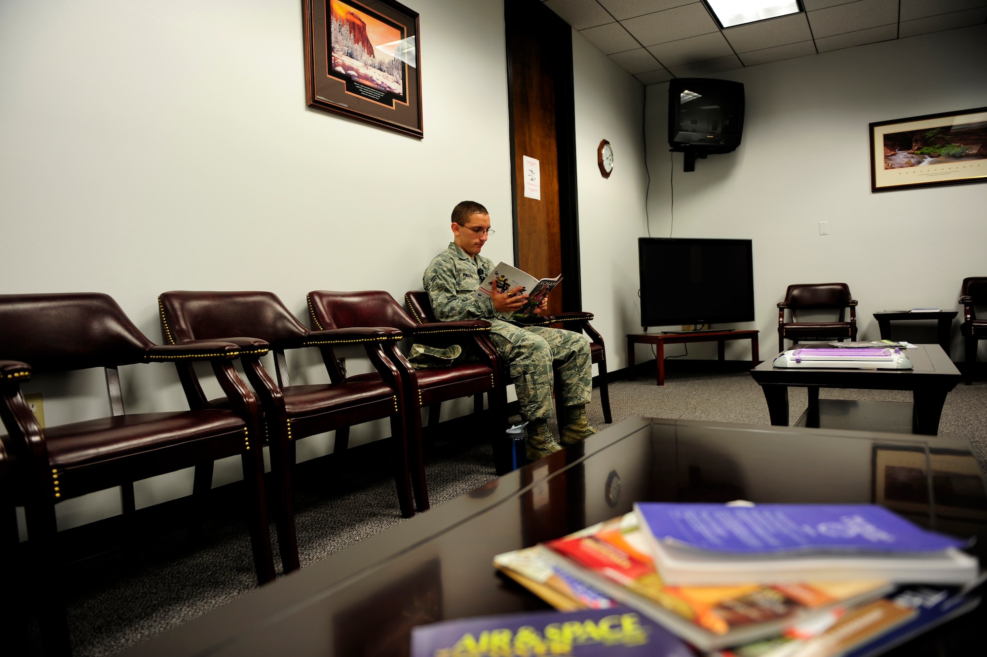 Airman 1st Class Kevin Pinaha, U.S. Air Forces Central system administrator,  reads a magazine as he waits in the 20th Fighter Wing’s legal office at Shaw Air Force Base, S.C., August 6, 2012. Legal offers many services ranging from creating and updating wills to legal matters dealing with housing and marriage. (U.S. Air Force photo by Airman 1st Class Daniel Blackwell/Released)