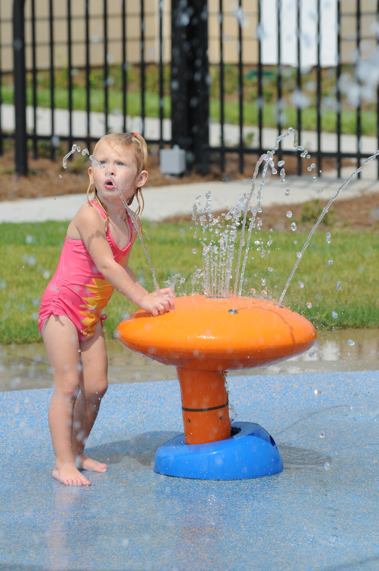 Two-year-old Layne Iverson, daughter of Angela and Capt. Kyle Iverson, 81st Surgical Operations Squadron, takes advantage of the splash pad at the Keesler Community Center in the Bay Ridge housing area August 7, 2012, at Keesler Air Force Base, Miss.  The center celebrated its opening with a ribbon-cutting ceremony and a tour of the facility, which also features an event room, business center, fitness room with a children’s play area, and an outdoor swimming pool.  (U.S. Air Force photo by Kemberly Groue)