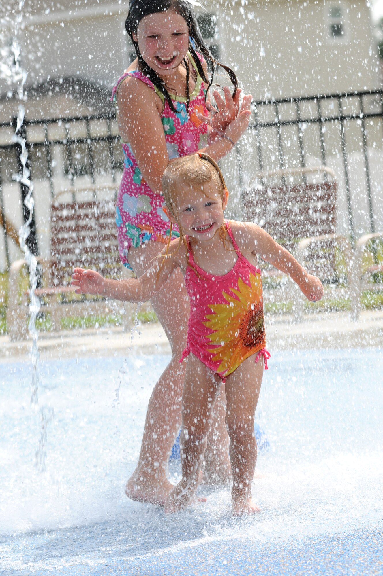 Emma Lewis, 8, and her cousin, Layne Iverson, 2, play together on the splash pad at the Keesler Community Center in the Bay Ridge housing area August 7, 2012, at Keesler Air Force Base, Miss.  Emma is visiting Layne, whose parents are Angela and Capt. Kyle Iverson, 81st Surgical Operations Squadron.  The center celebrated its opening with a ribbon-cutting ceremony and a tour of the facility, which also features an event room, business center, fitness room with a children’s play area, and an outdoor swimming pool.  (U.S. Air Force photo by Kemberly Groue)