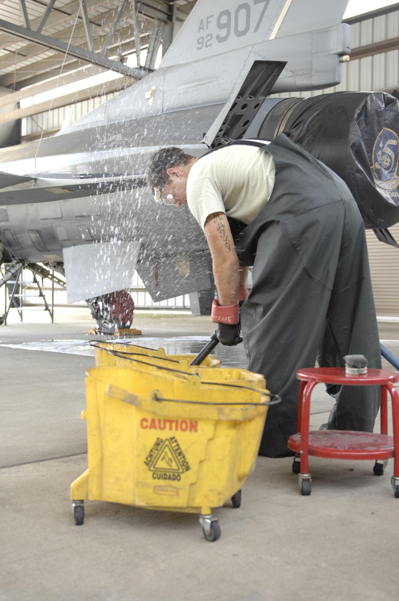 Airman 1st Class Jake Palmiero, 20th Aircraft Maintenance Squadron, Gamblers Aircraft Maintenance Unit electrical environmental specialist, fills up buckets of soap to wash an F-16 Fighter Falcon at Shaw Air Force Base, S.C., July 31, 2012. It takes more than three hours to wash an F-16. It involves taping up sensitive electrical equipment and all openings into the plane, cleaning the aircraft of debris, removing the tape and checking the paint for corrosion which could weaken the plane’s integrity. Palmiero is a native of Kenmore, N.Y. (U.S. Air Force photo by Airman 1st Class Krystal M. Jeffers/Released)