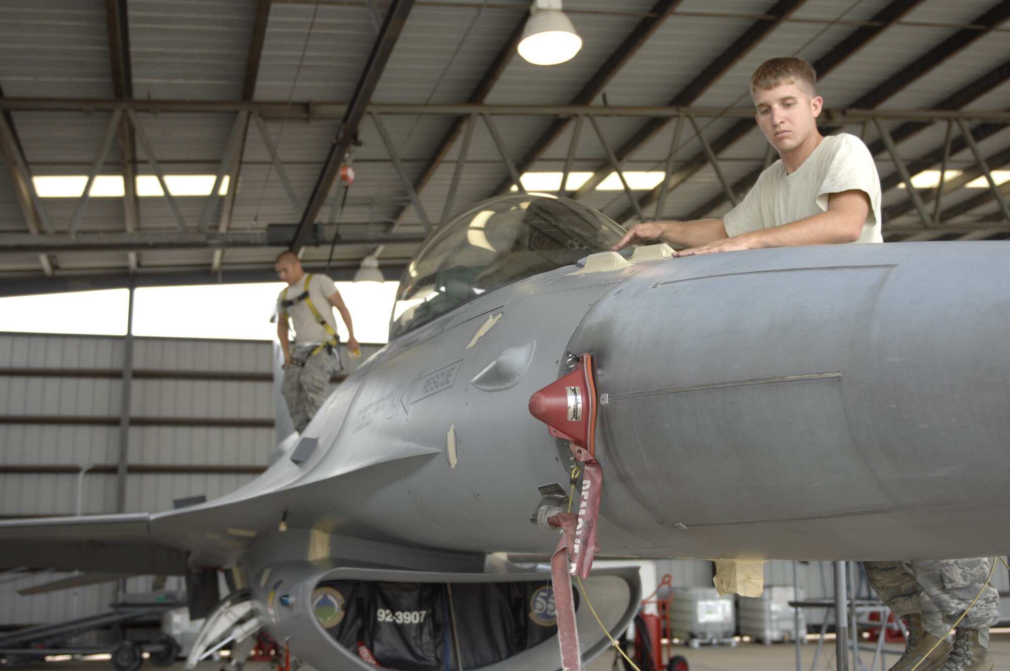 Staff Sgt. Kyle Padgett, 20th Aircraft Maintenance Squadron, Gamblers Aircraft Maintenance Unit dedicated crew chief, and Airman 1st Class Matthew Andrade, Gamblers AMXU crew chief, apply tape to sensitive electrical equipment on an F-16 Fighting Falcon at Shaw Air Force Base, S.C., July 31, 2012. The plane was being prepared for the cleaning, which happens every 180 days. Padgett is a native of Aiken, S.C., while Andrade is a native of Vacaville, Calif. (U.S. Air Force photo by Airman 1st Class Krystal M. Jeffers/Released)