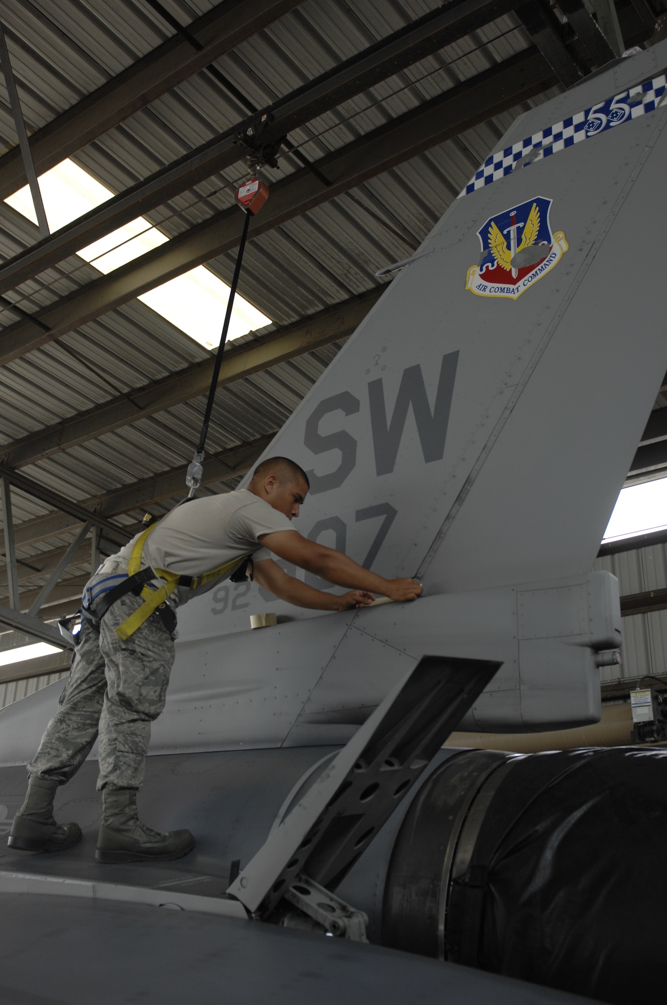 Airman 1st Class Matthew Andrade, a native of Vacaville, Calif., and an F-16 crew chief assigned to the 20th Aircraft Maintenance Squadron, Gamblers Aircraft Maintenance Unit applies tape to sensitive electrical equipment and any openings on an F-16 Fighting Falcon at Shaw Air Force Base, S.C., July 31, 2012. Andrade was preparing the plane to be cleaned of debris that builds up during flight. To prevent corrosion, the planes are washed every 180 days. (U.S. Air Force photo by Airman 1st Class Krystal M. Jeffers/Released)