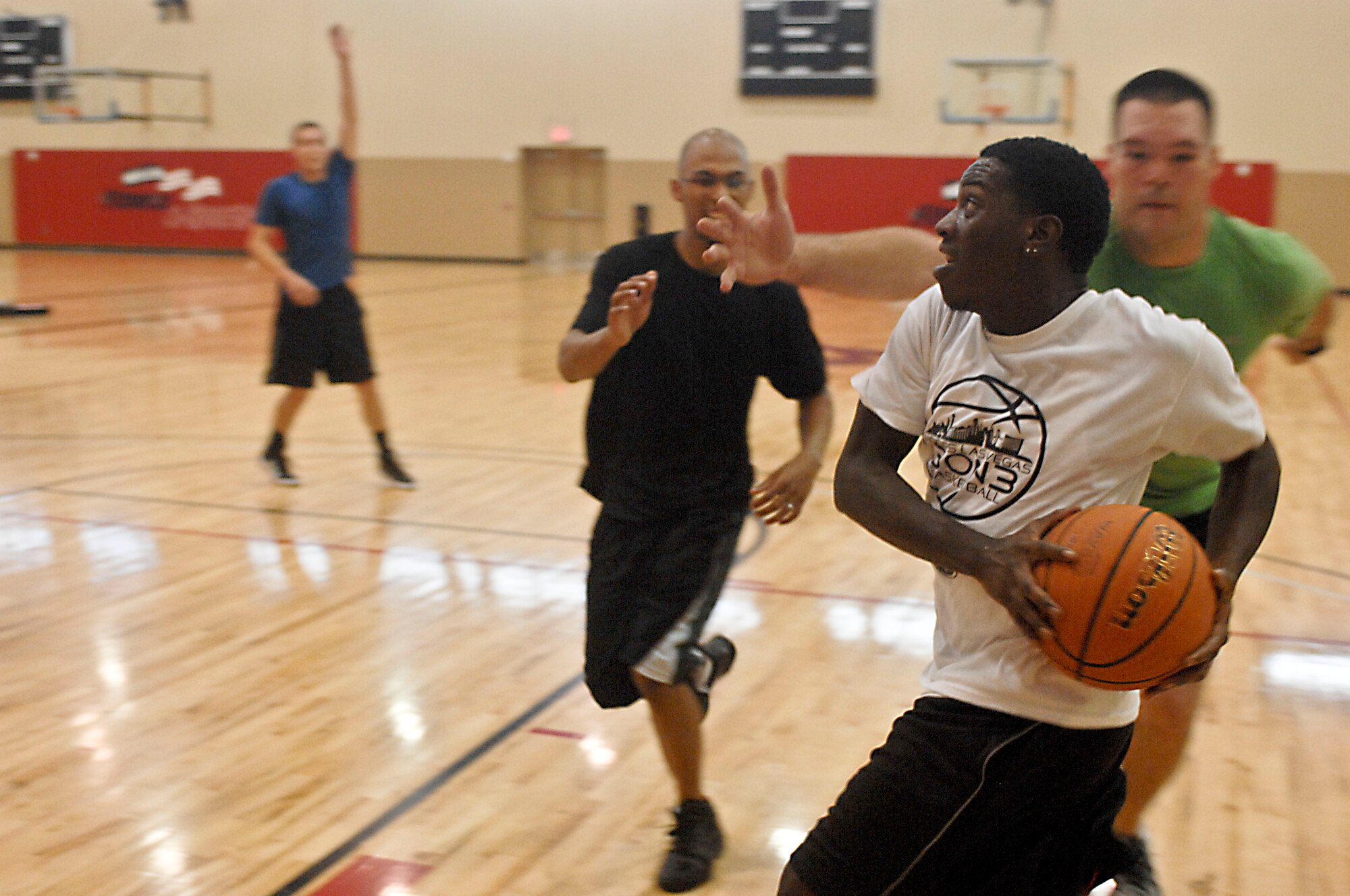 Tefarious Woods drives to the hoop during a three-on-three basketball game Aug. 4, 2012, at the Warrior Fitness Center at Nellis Air Force Base, Nev. The game was part of the base chapel's sports day and their outreach program.
