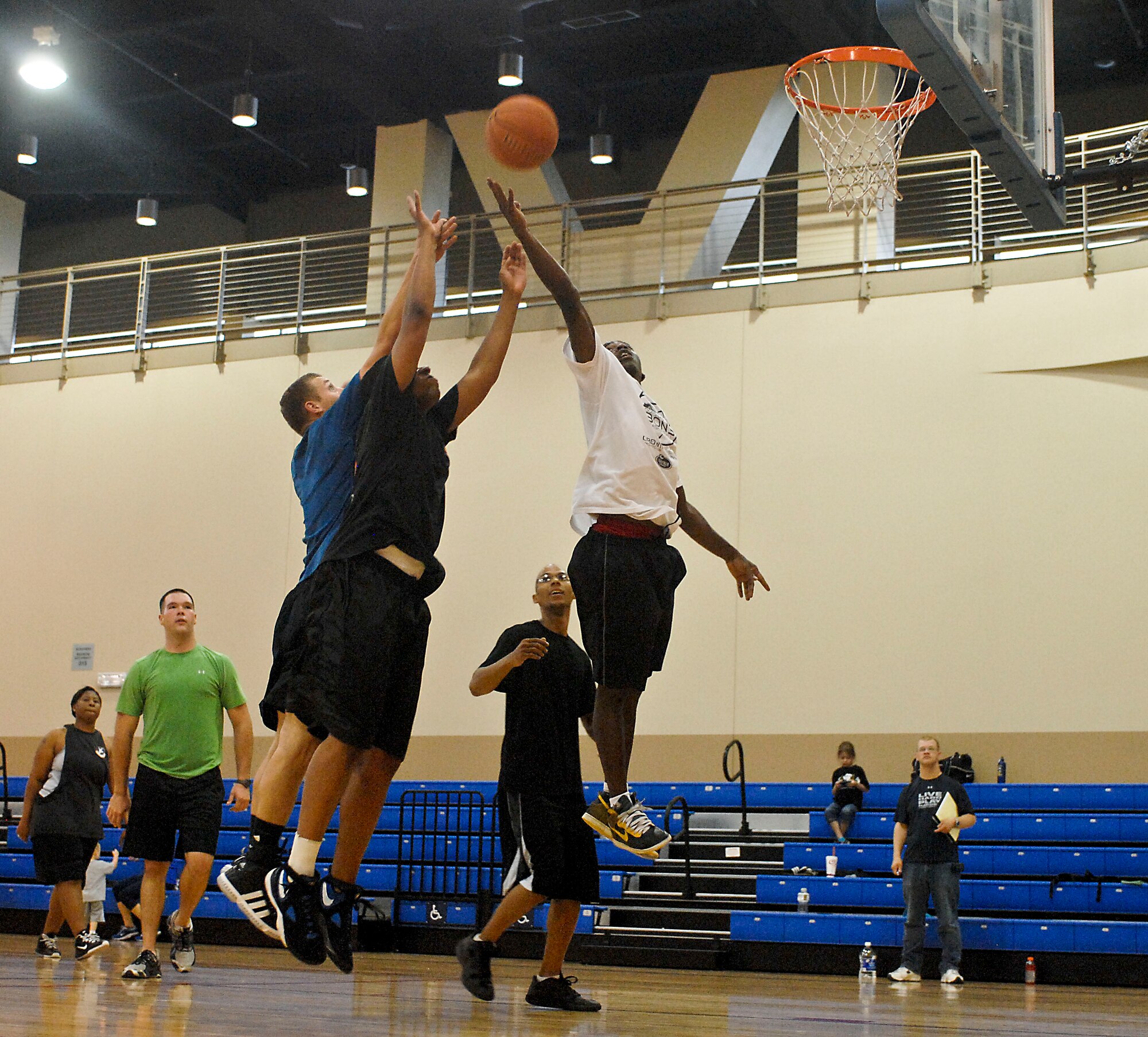 Chapel Outreach program participants jump for a rebound during a three on three basketball game Aug. 4, 2012 at the Warrior Fitness Center at Nellis Air Force Base, Nev. The game was part of the base chapel's sports day held in an effort to encourage Airmen and friends to get to know one another. For more information on the chapel's outreach program or upcoming events contact the base chapel at (702) 652-2950. (U.S. Air Force photo by Senior Airman Jack Sanders)

