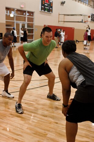 Bryan Robertson guards Fallon Robinson Aug. 4, 2012 at the Warrior Fitness Center during a three on three basketball game at Nellis Air Force Base, Nev. The base chapel held the game as part of their sports day in an effort to have fellowship and build camaraderie.  For more information on the chapel's outreach program or upcoming events contact the base chapel at (702) 652-2950.(U.S. Air Force photo by Senior Airman Jack Sanders)