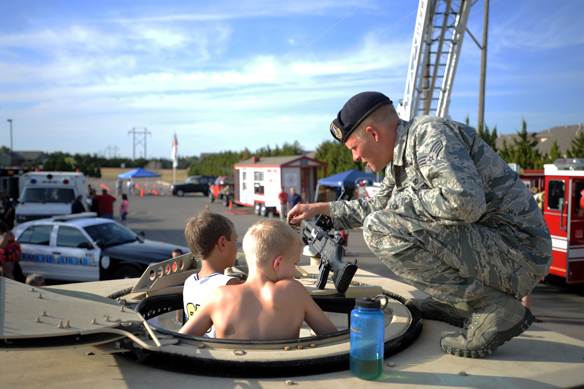Senior Airman Erik Ippel, 22nd Security Forces Squadron police services journeyman, helps children as they explore a Humvee on display at the National Night Out event August 6, 2012, Derby, Kan. Local law enforcement agencies gather at the annual event to raise awareness in the community about crime and drug prevention. (U.S. Air Force photo/Airman 1st Class Victor J. Caputo)
