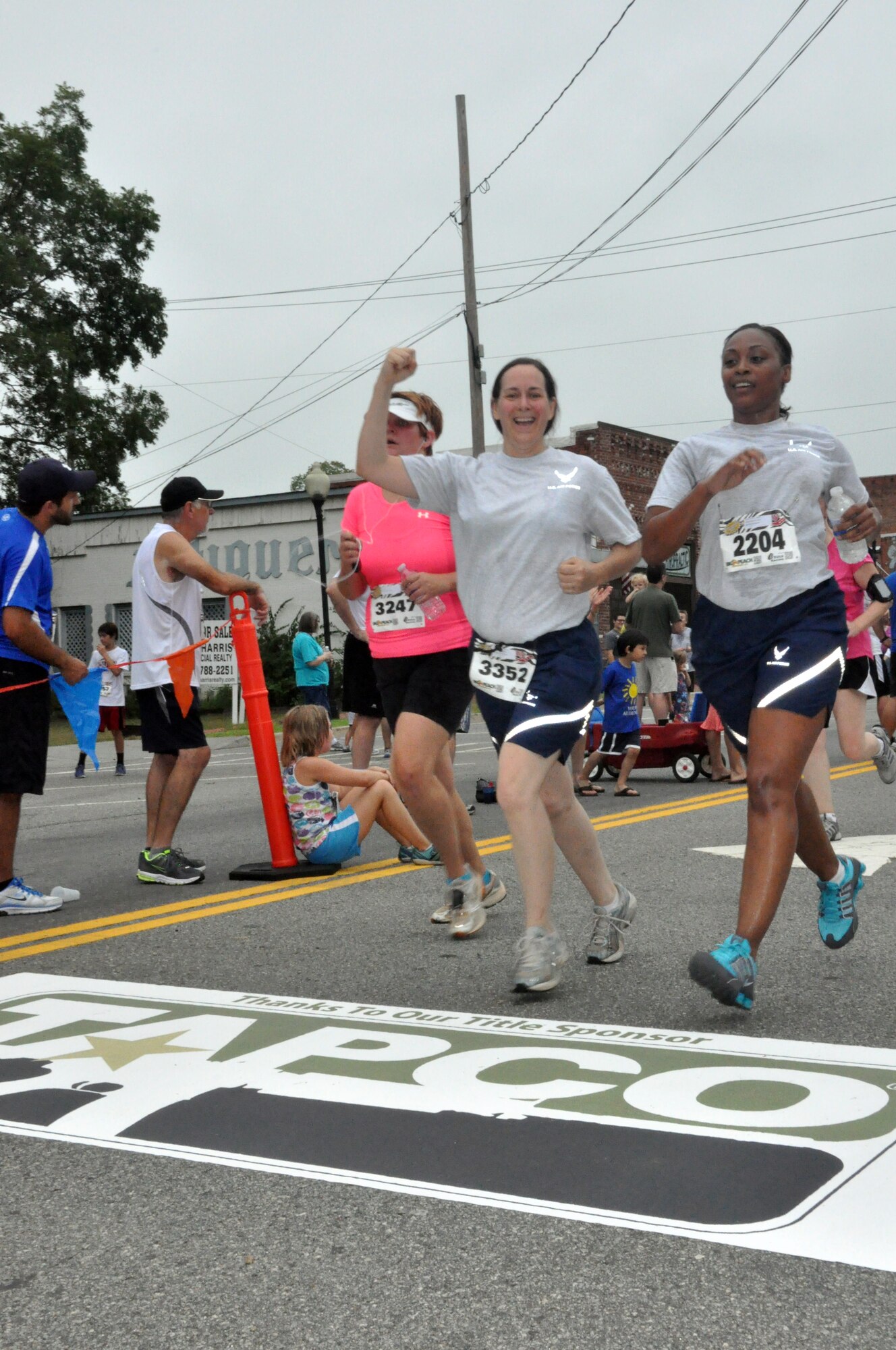 Members of the 94th Communications Squadron ran a 5k in support of the Wounded Warrior Project on Aug 4 in Kennesaw, Ga. Staff Sgt. Kathleen Welsch, cyber transport technician, and Senior Airman Cythia Carson, client system administration, cross the finish line. (U.S. Air Force photo/Senior Airman Christina Bozeman)