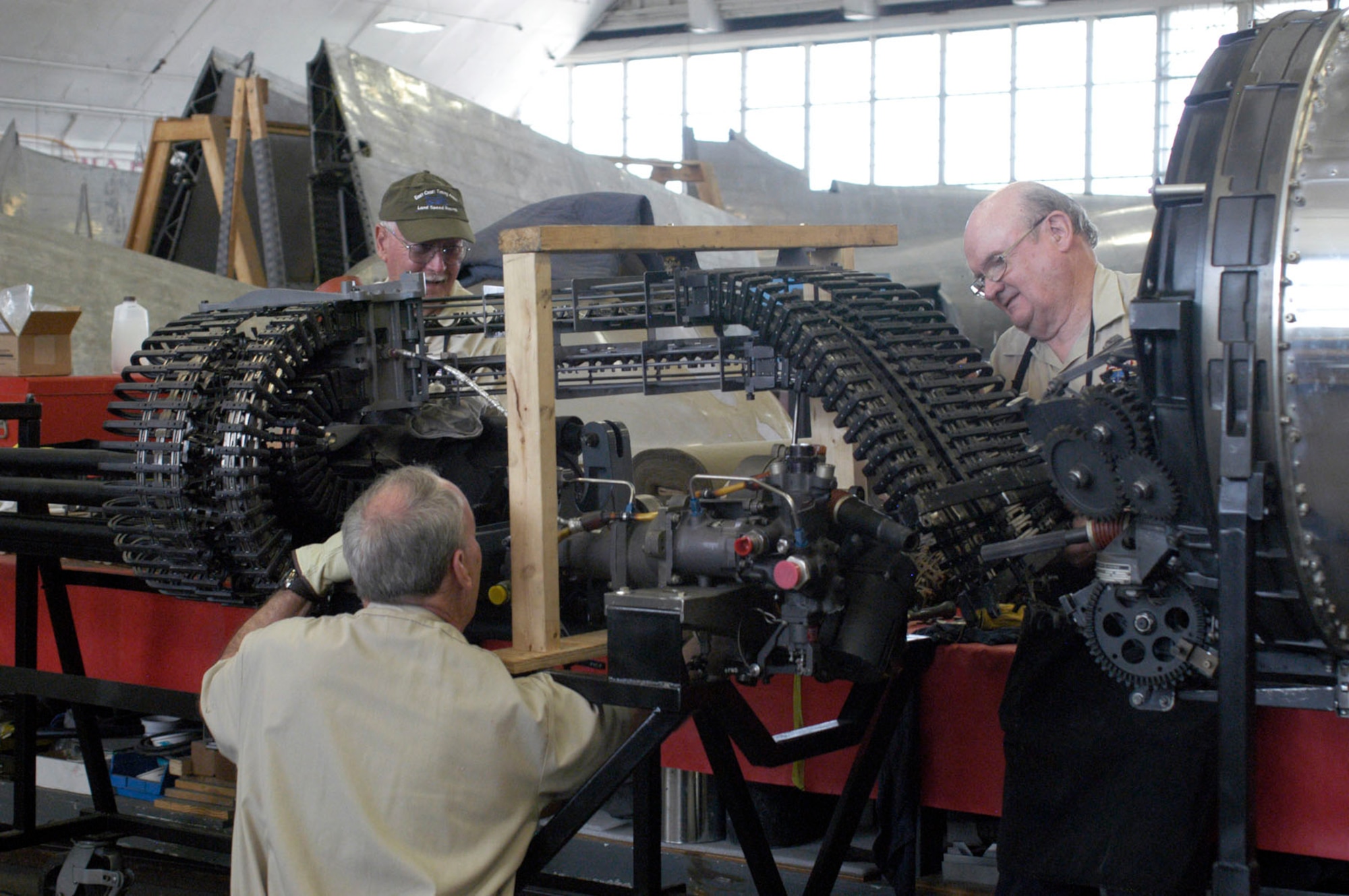 Restoration volunteers (from left to right) Ed Kienle, Garry Guthrie and Lou Thole load cartridges into the GAU-8/A drum. (U.S. Air Force photo)