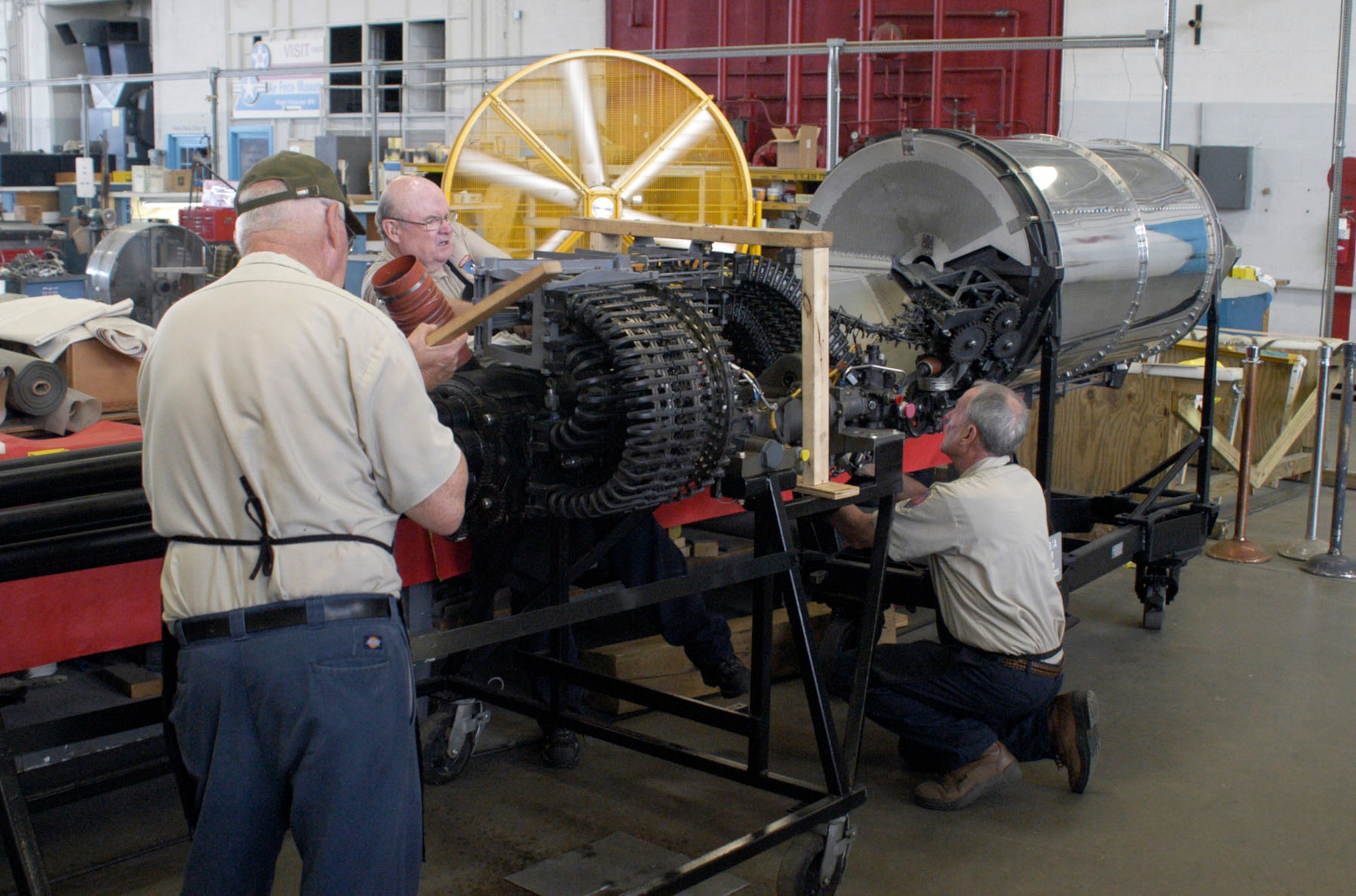 Restoration volunteers (from left to right) Ed Kienle, Garry Guthrie and Lou Thole load cartridges into the GAU-8/A drum. (U.S. Air Force photo)
