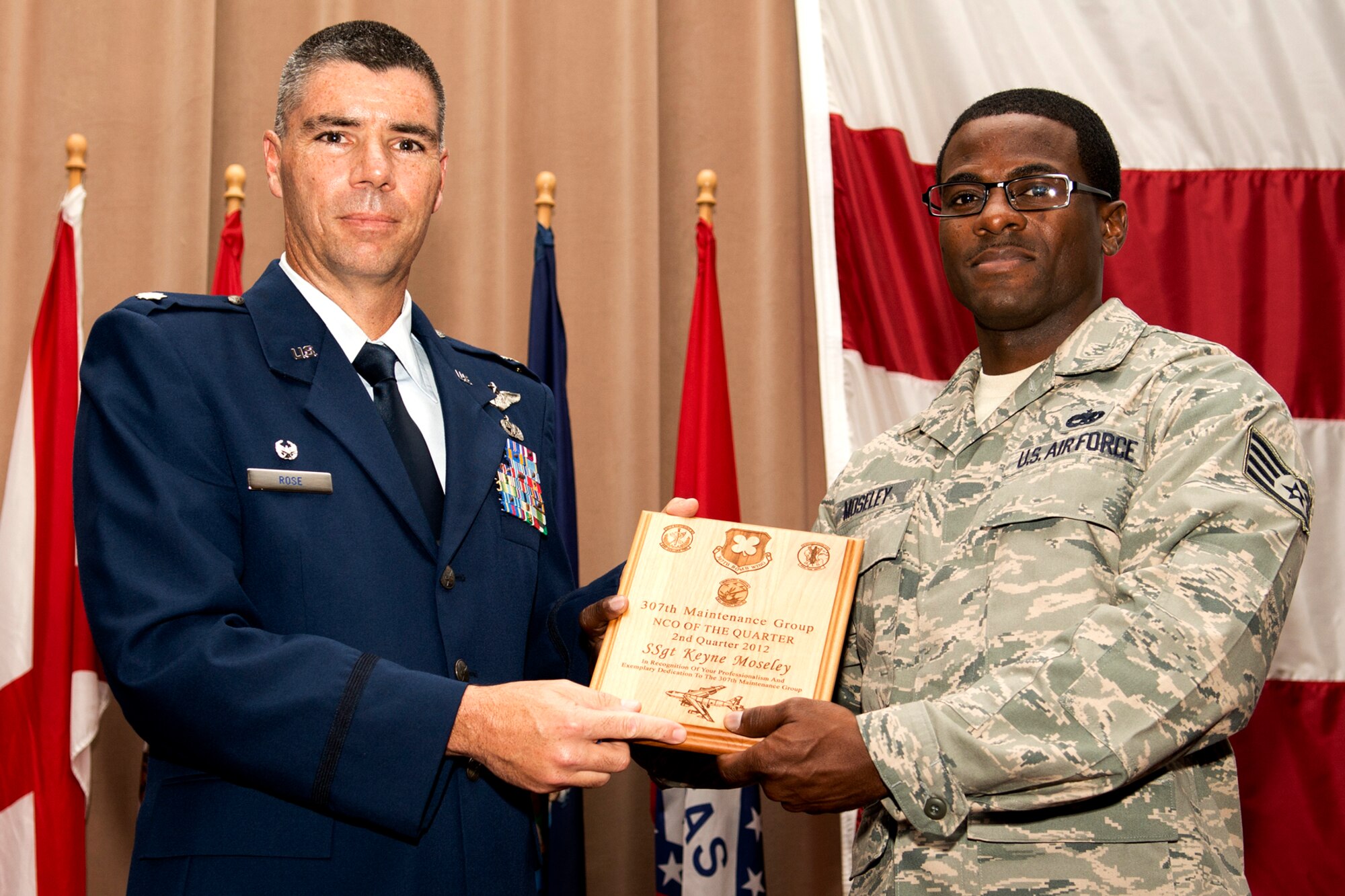 U.S. Air Force Lt. Col. Kenneth Rose, 307th Maintenance Group commander, presents U.S. Air Force Staff Sgt. Keyne Moseley with a plague during a commander's call ceremony on Aug. 5, 2012, Barksdale Air Force Base, La. Moseley was selected as the Noncommissioned Officer of the Quarter for the second quarter of 2012. (U.S. Air Force photo by Master Sgt. Greg Steele/Released)
