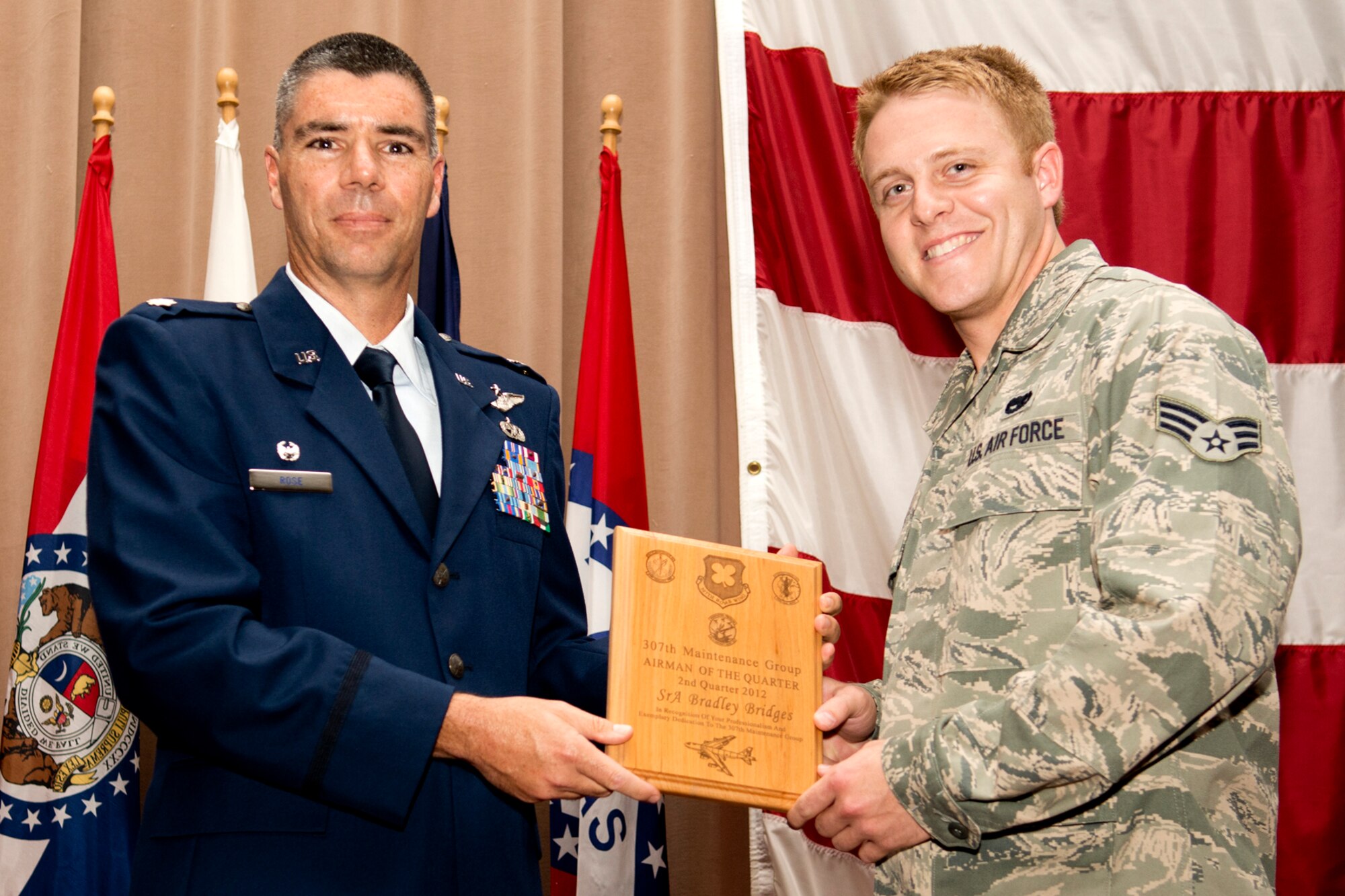U.S. Air Force Lt. Col. Kenneth Rose, 307th Maintenance Group commander, presents U.S. Air Force Senior Airman Bradley Bridges with a plague during a commander's call ceremony on Aug. 5, 2012, Barksdale Air Force Base, La. Bridges was selected as the Airman of the Quarter for the second quarter of 2012. (U.S. Air Force photo by Master Sgt. Greg Steele/Released)